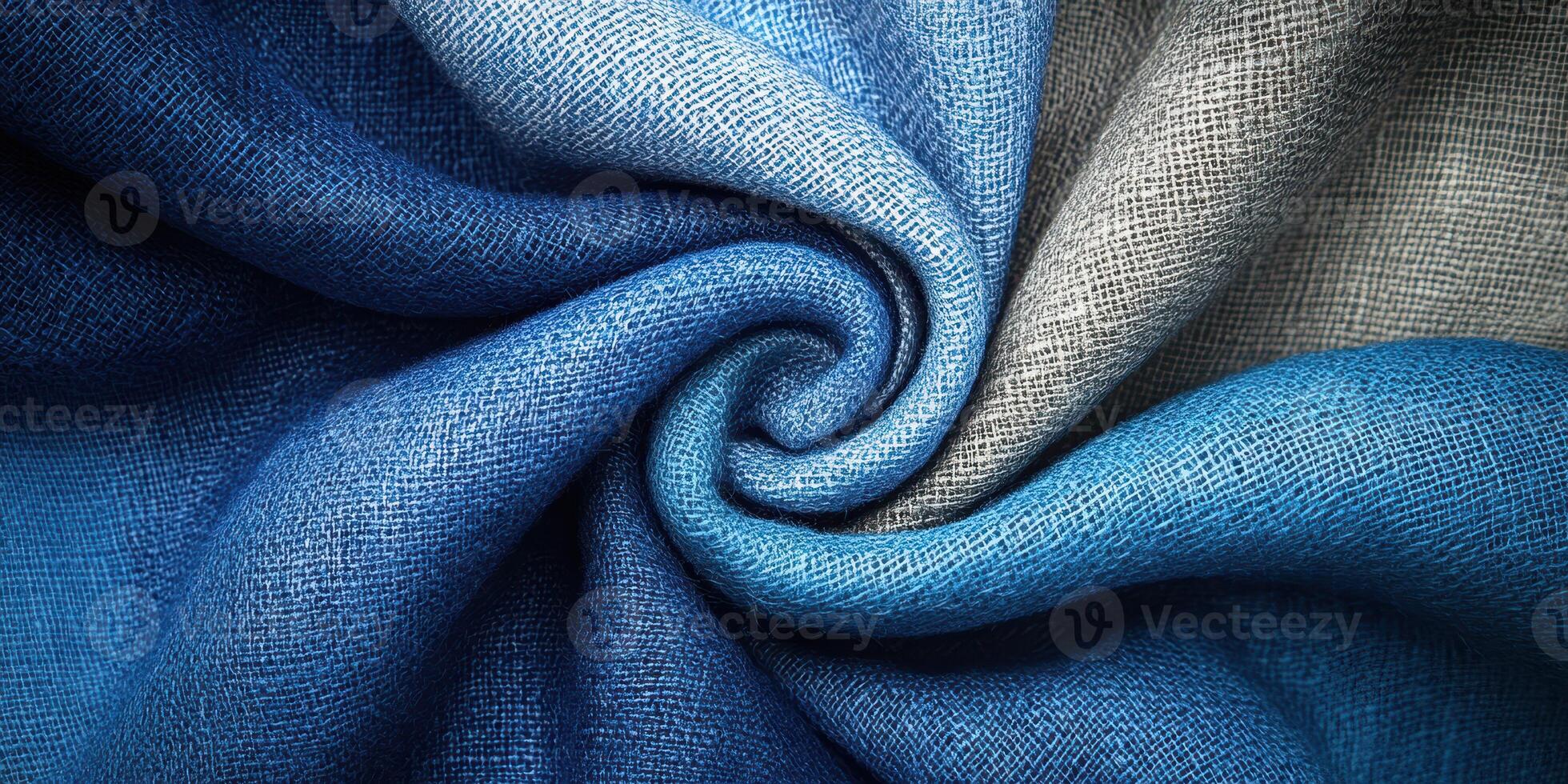 Fabric texture in a spiral arrangement showcasing shades of blue and a hint of gray during daylight photo