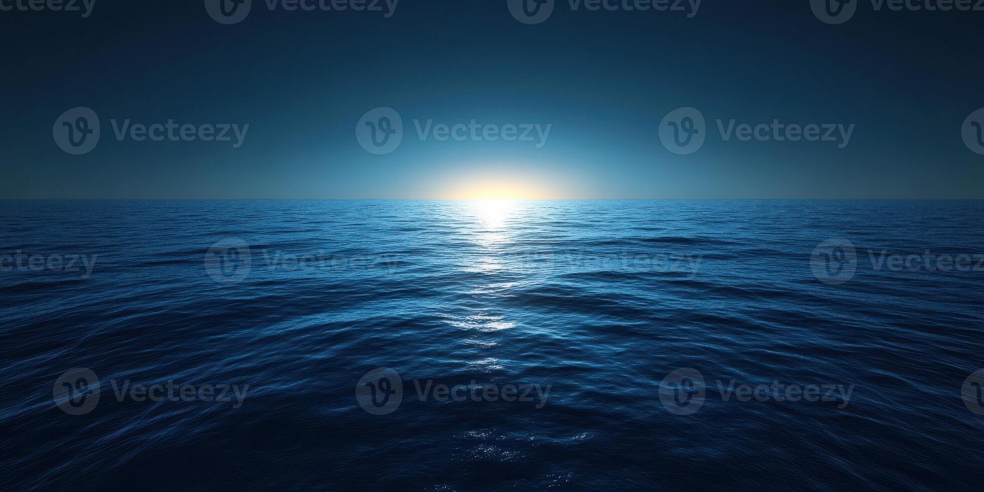 Calm ocean waves reflect the soft glow of a sunrise over the horizon at dawn photo