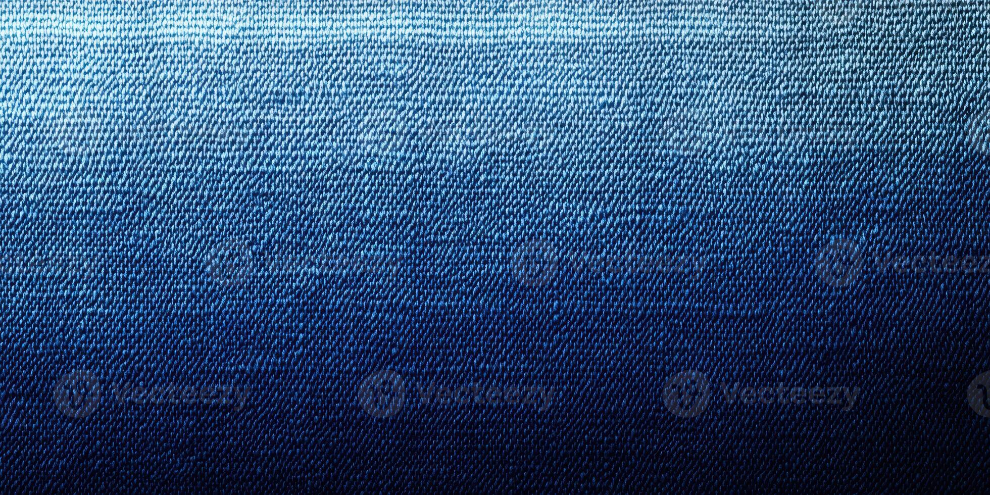 Textured fabric with a gradient from light blue to deep navy blue showing intricate weaving patterns under soft lighting photo