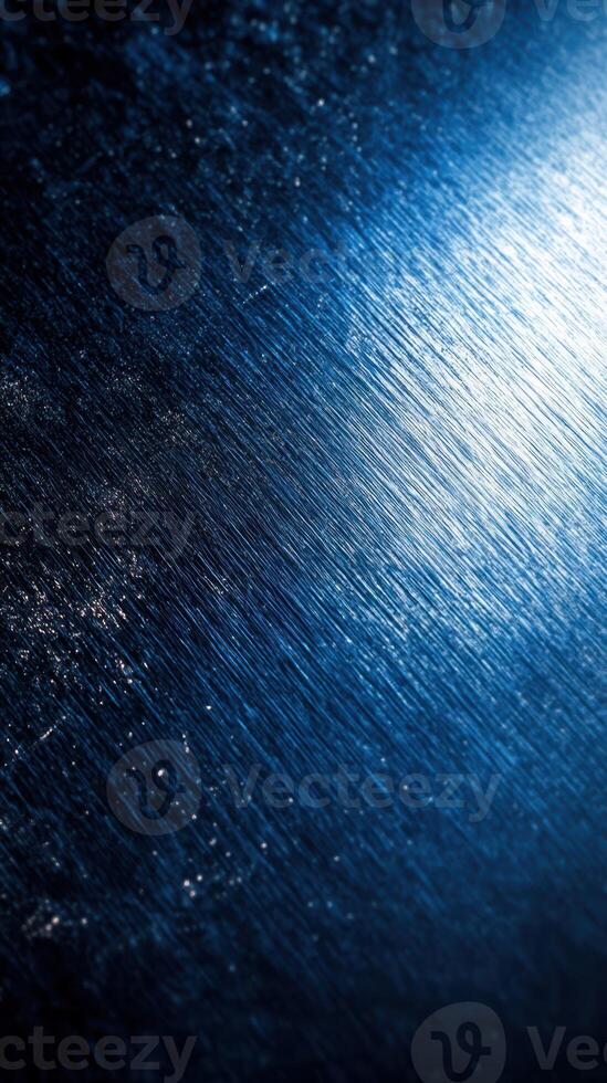 Textured blue metallic surface with shining highlights and subtle patterns during late evening light photo