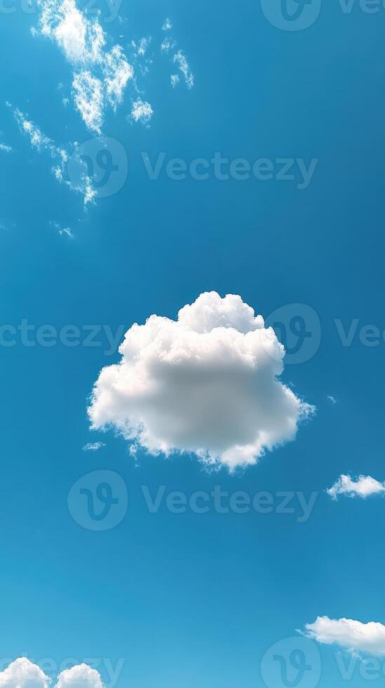 Fluffy white cloud drifting in a bright blue sky on a sunny afternoon photo