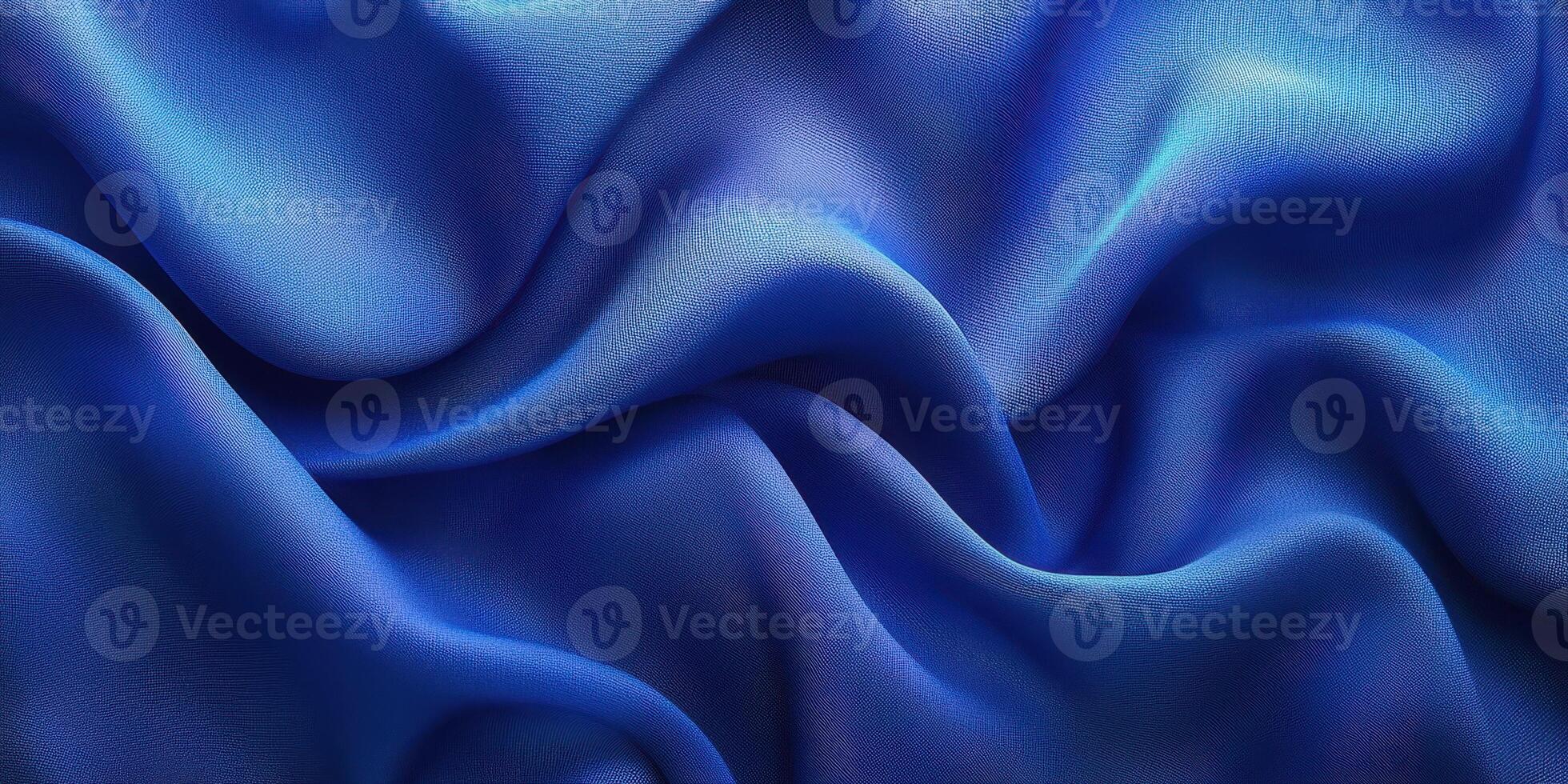 Elegant blue satin fabric draped softly in folds creating a luxurious texture and rich color in natural light photo