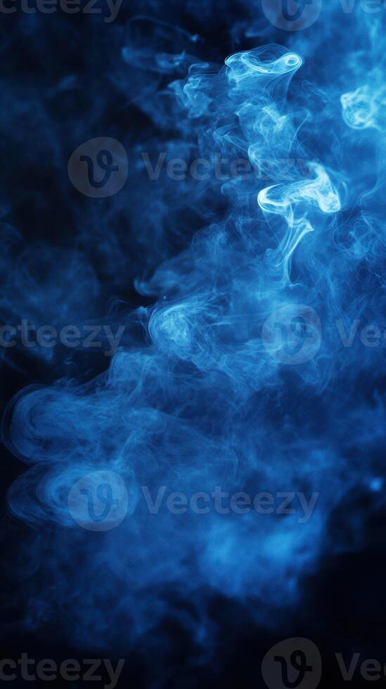 Blue smoke swirling in dark background creating an ethereal and mysterious atmosphere photo