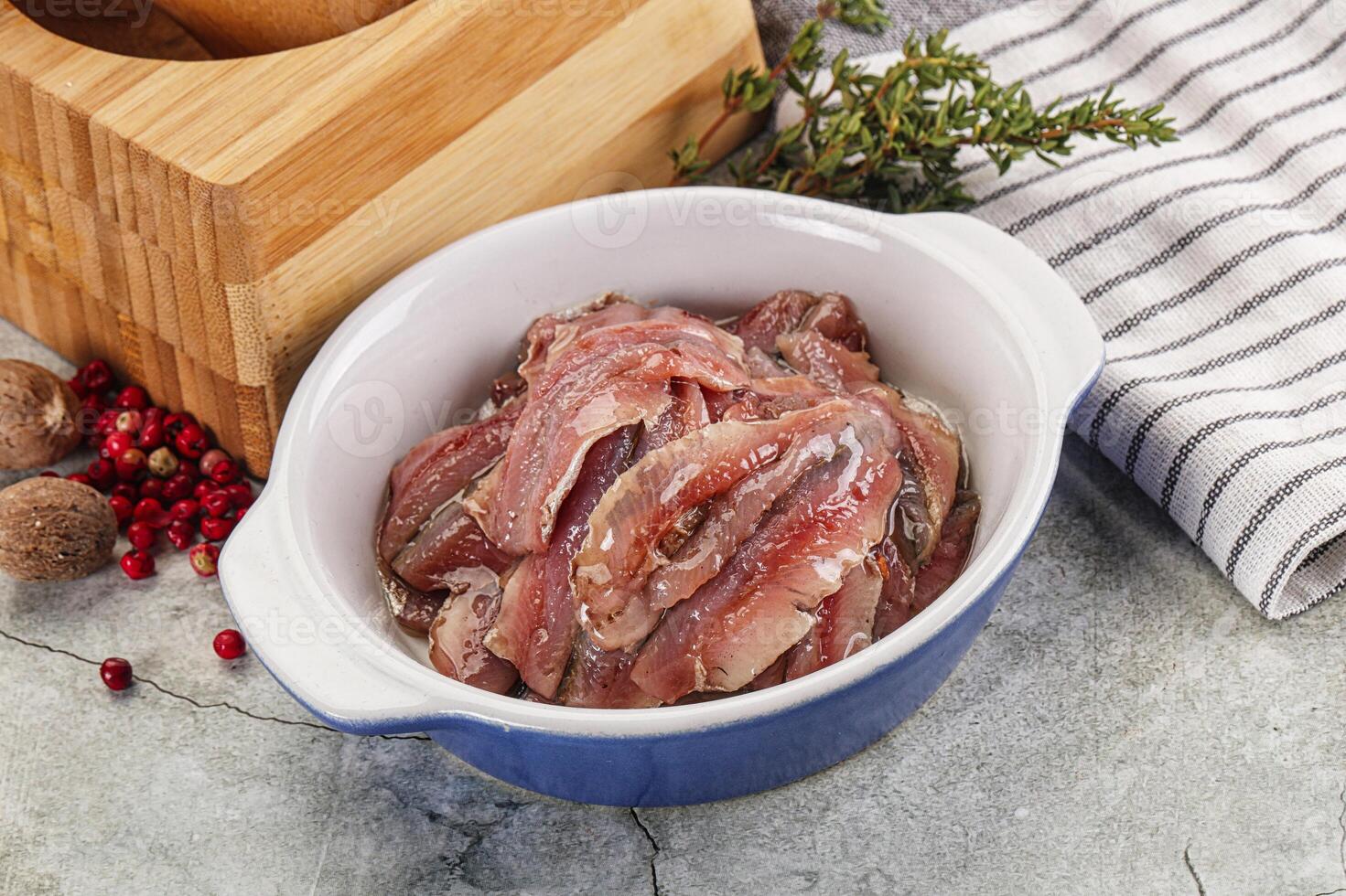A bowl of raw meat sitting on a table next to a knife photo