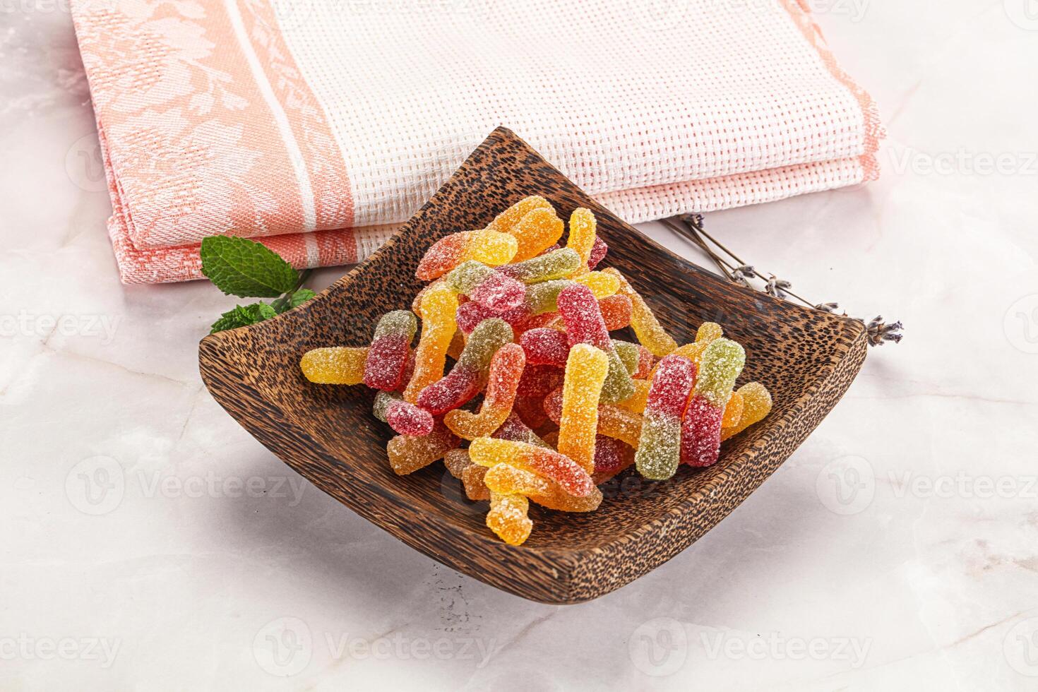 A wooden bowl filled with gummy candies photo