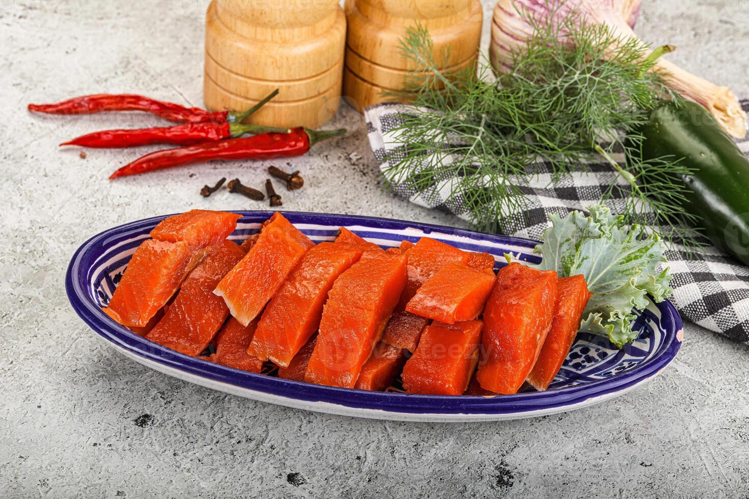 A plate of sliced salmon and vegetables on a table photo