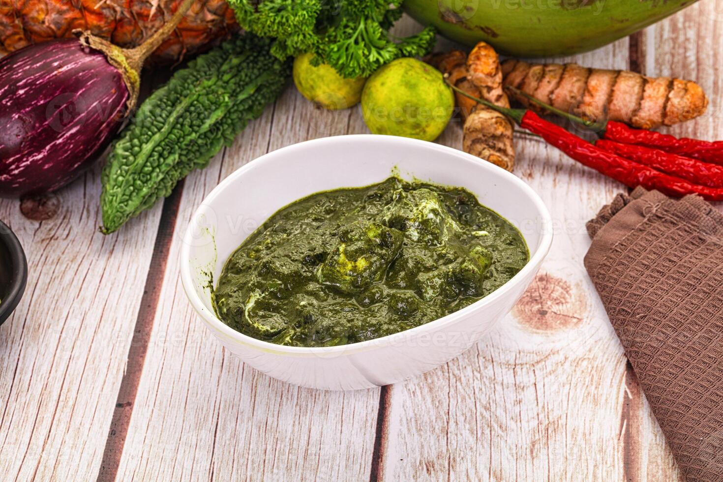 A bowl of green food sitting on a table photo