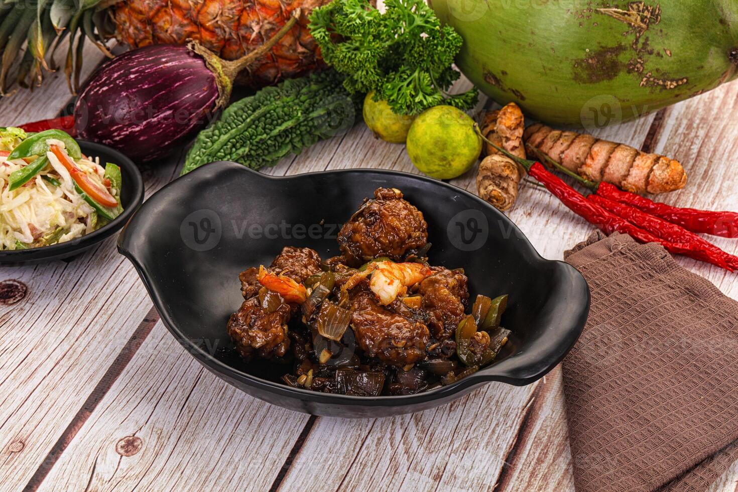 A bowl of food with meat, vegetables and a pineapple photo