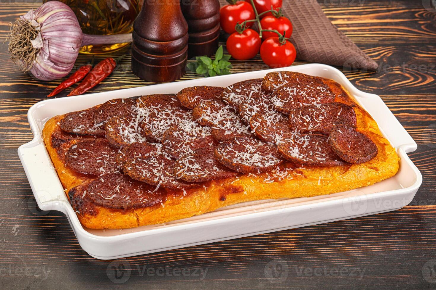 A white dish with meat and vegetables on a table photo