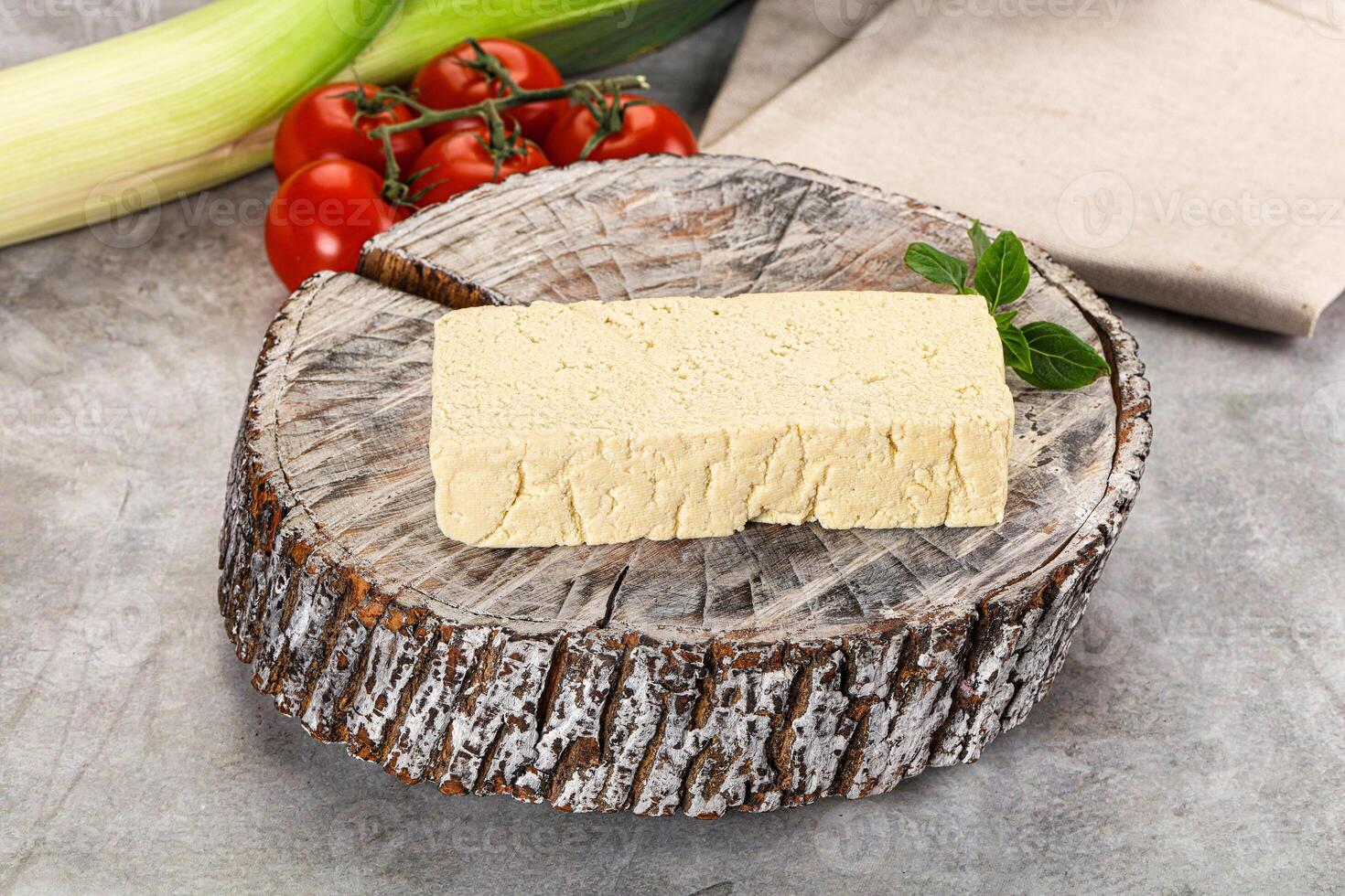 A piece of cheese on a piece of wood photo