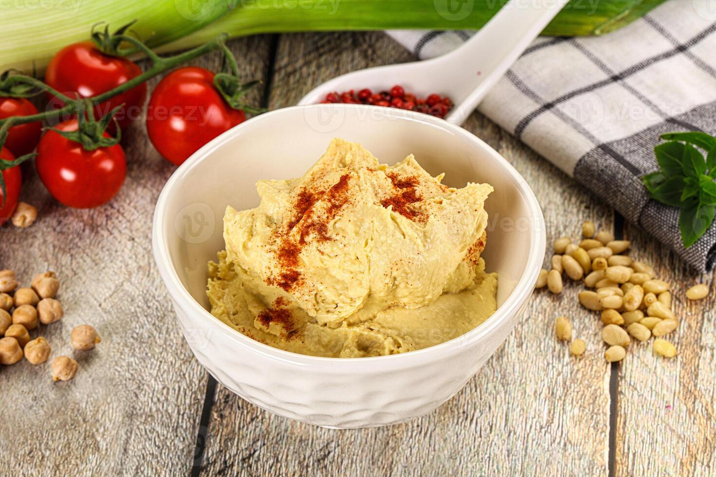 A bowl of hummus with some vegetables and spices photo