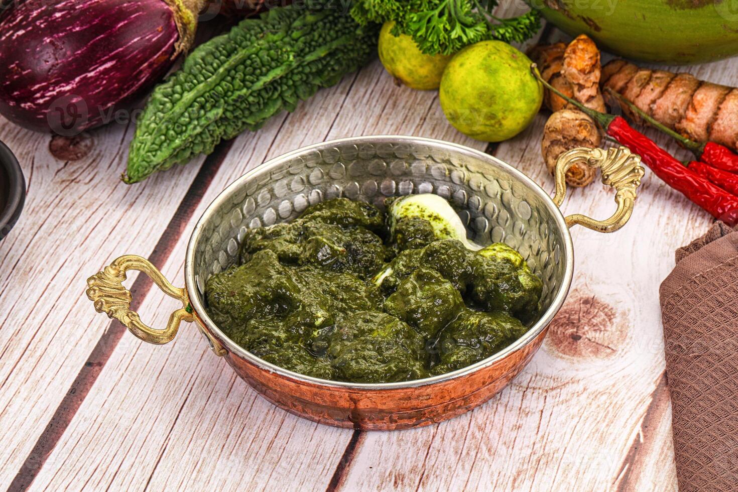 A bowl of green food sitting on a table photo