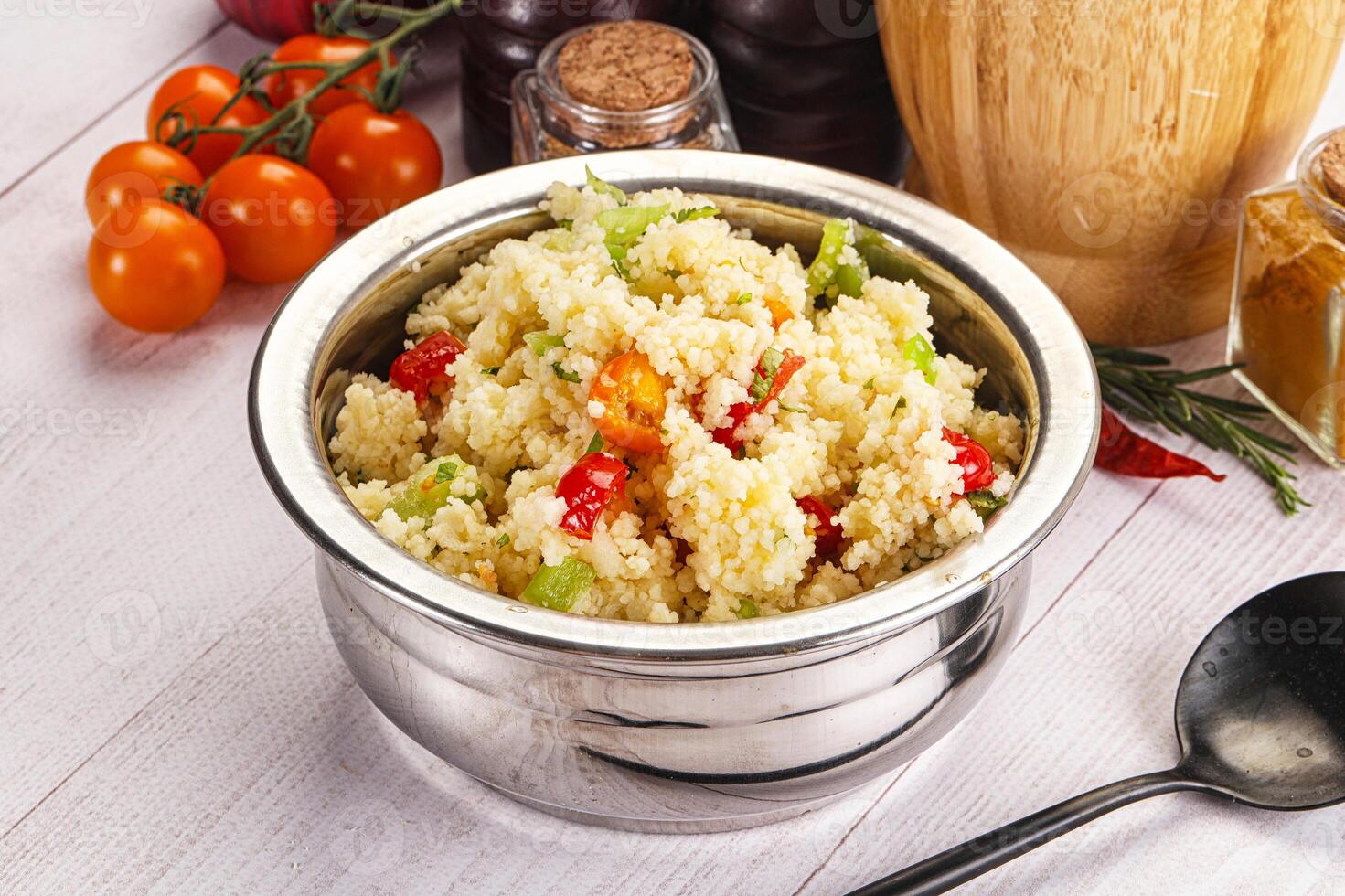 A bowl of food with a spoon and a bottle of ketchup photo
