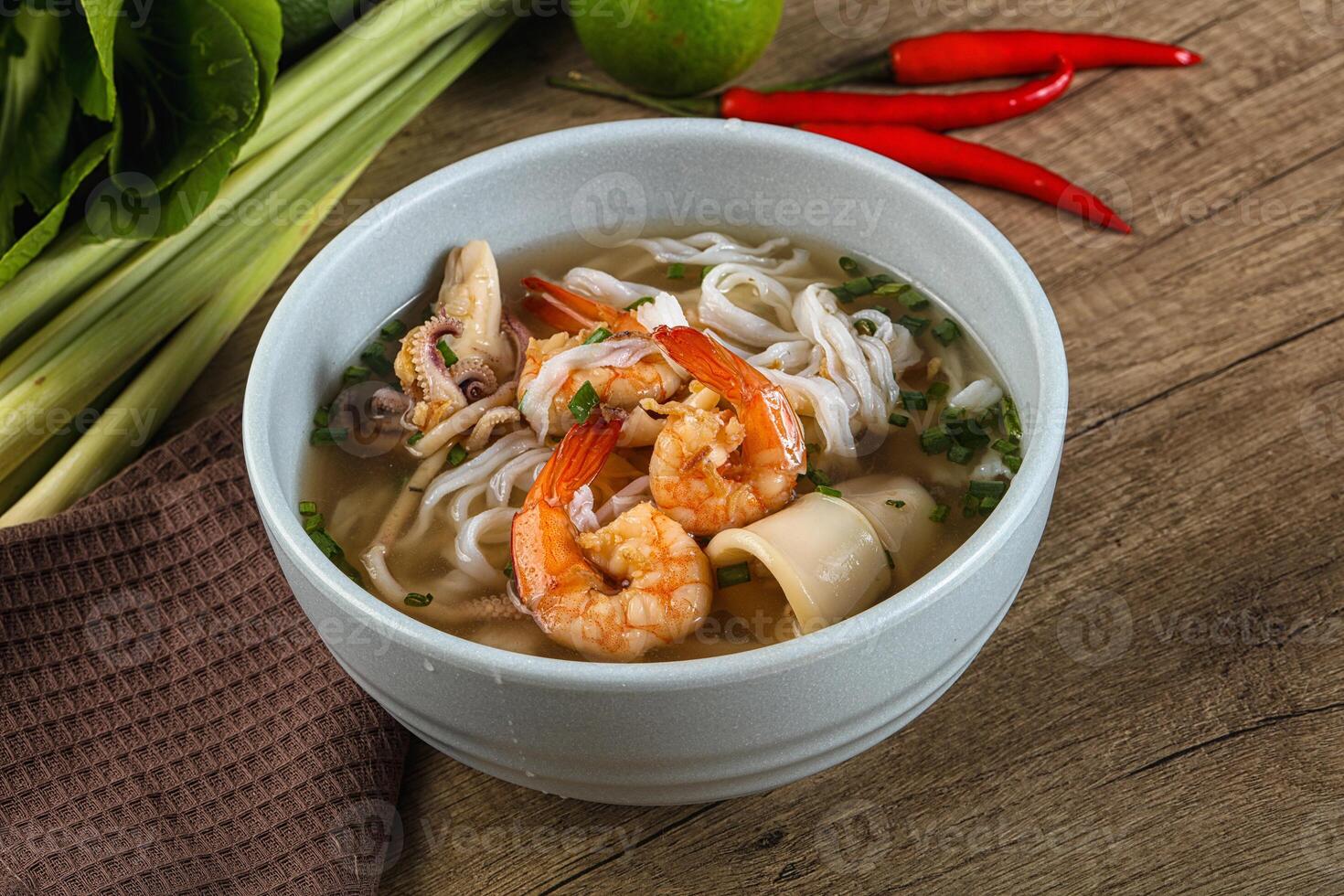 A bowl of soup with shrimp and vegetables photo