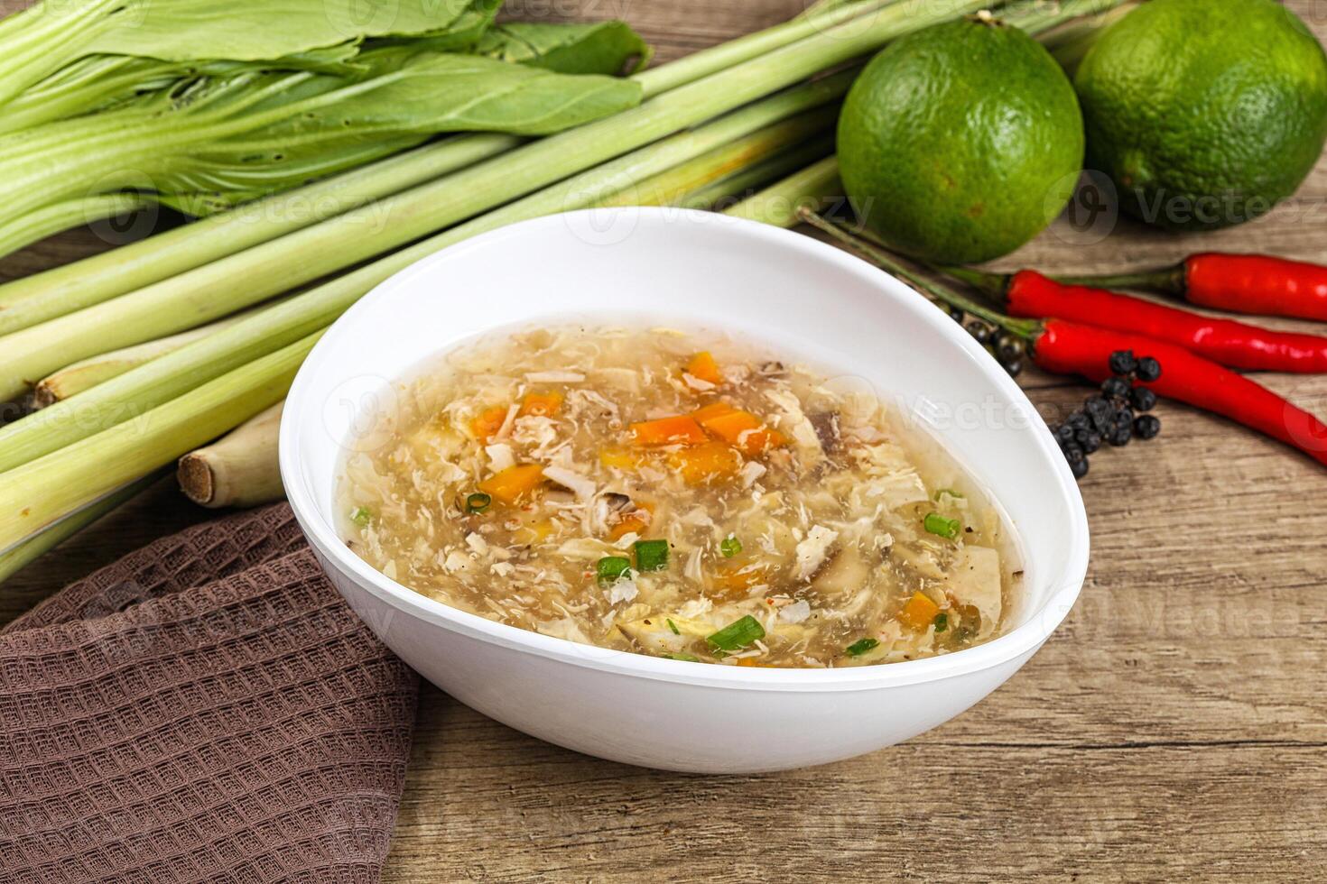 A bowl of soup with vegetables and a spoon photo