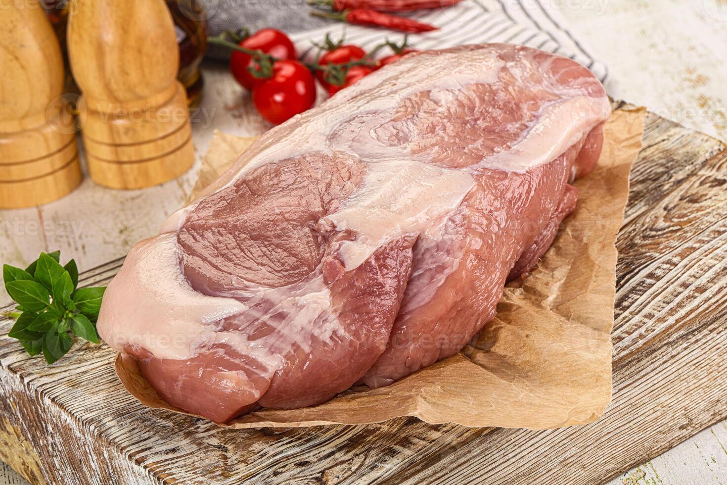 A piece of meat on a wooden cutting board photo
