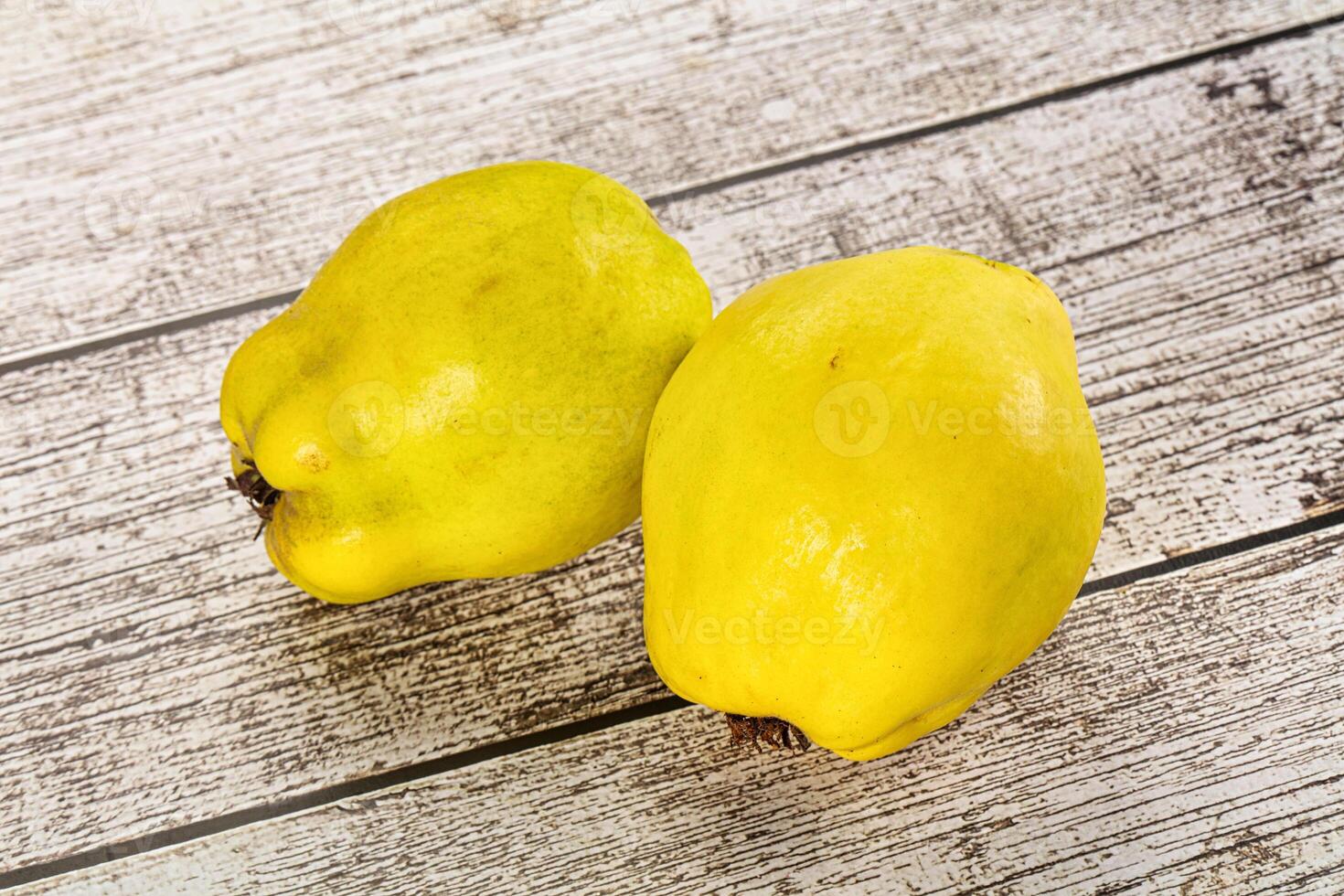 Two yellow fruits on a wooden table photo