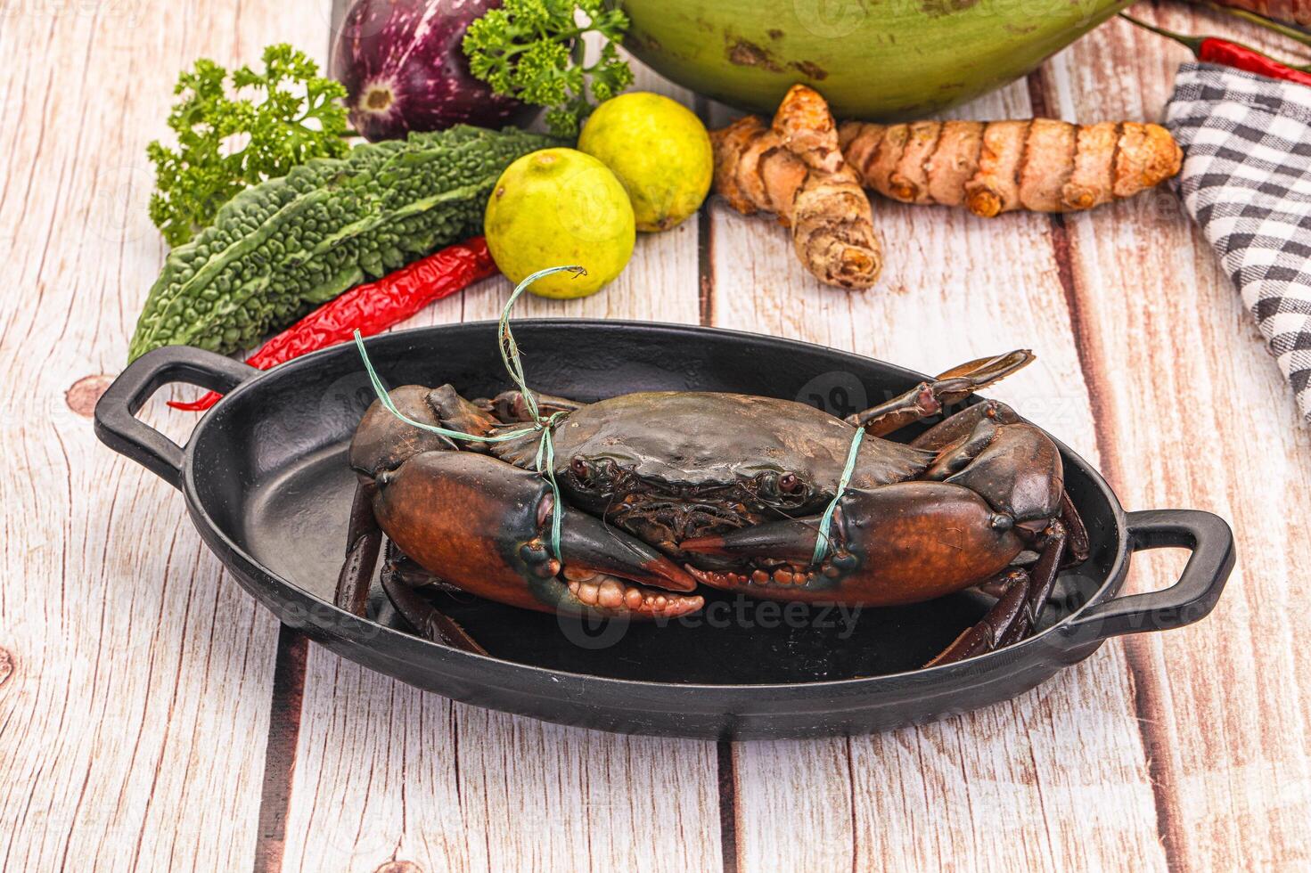 A crab in a pan with vegetables and spices photo