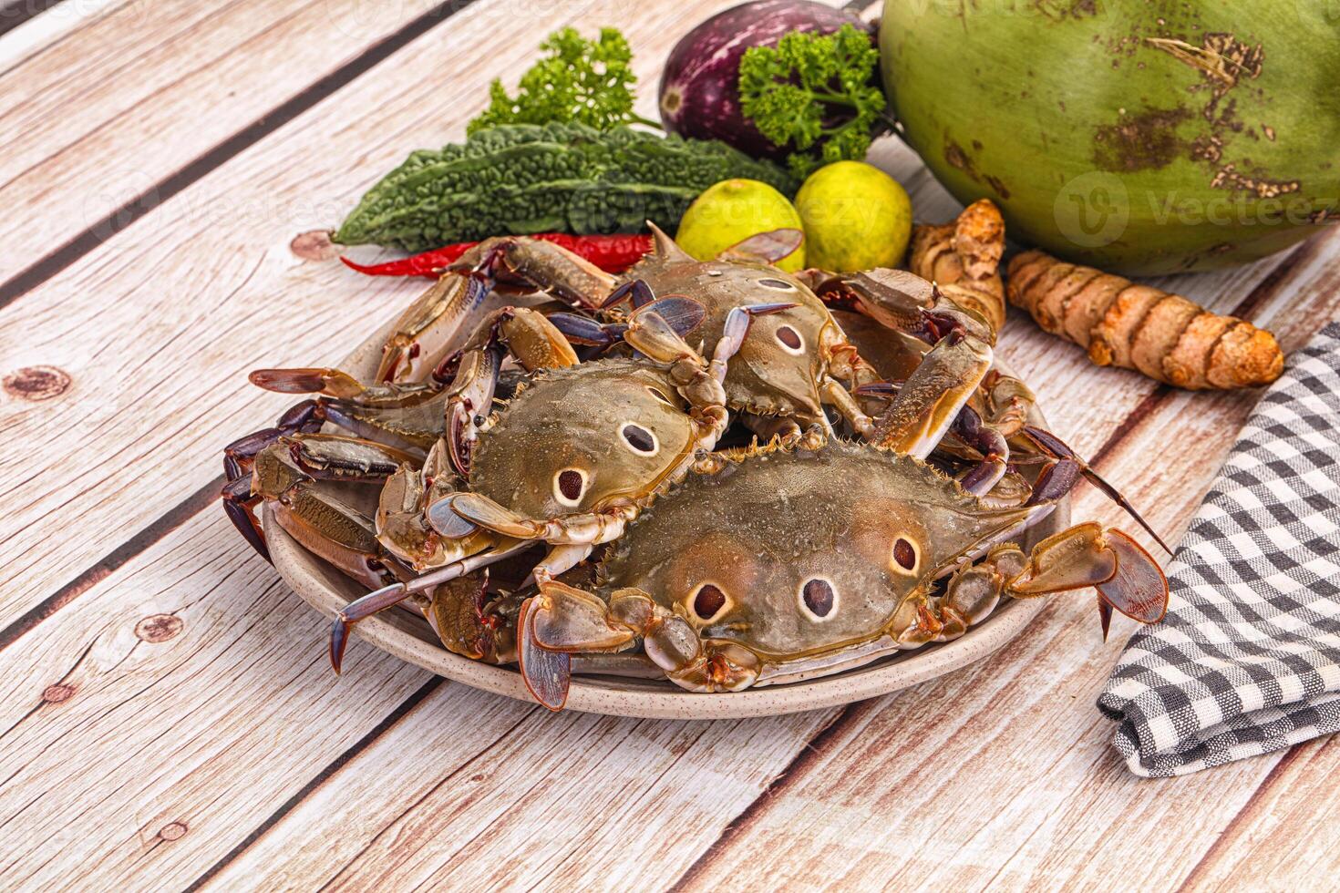 A plate of crabs on a table with other vegetables photo