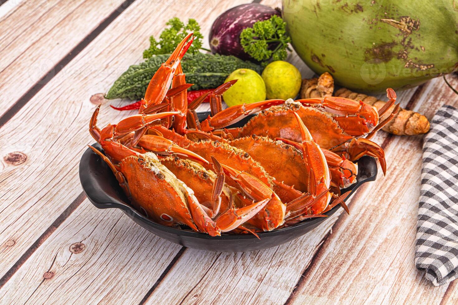 A bowl of crabs on a table with other food photo