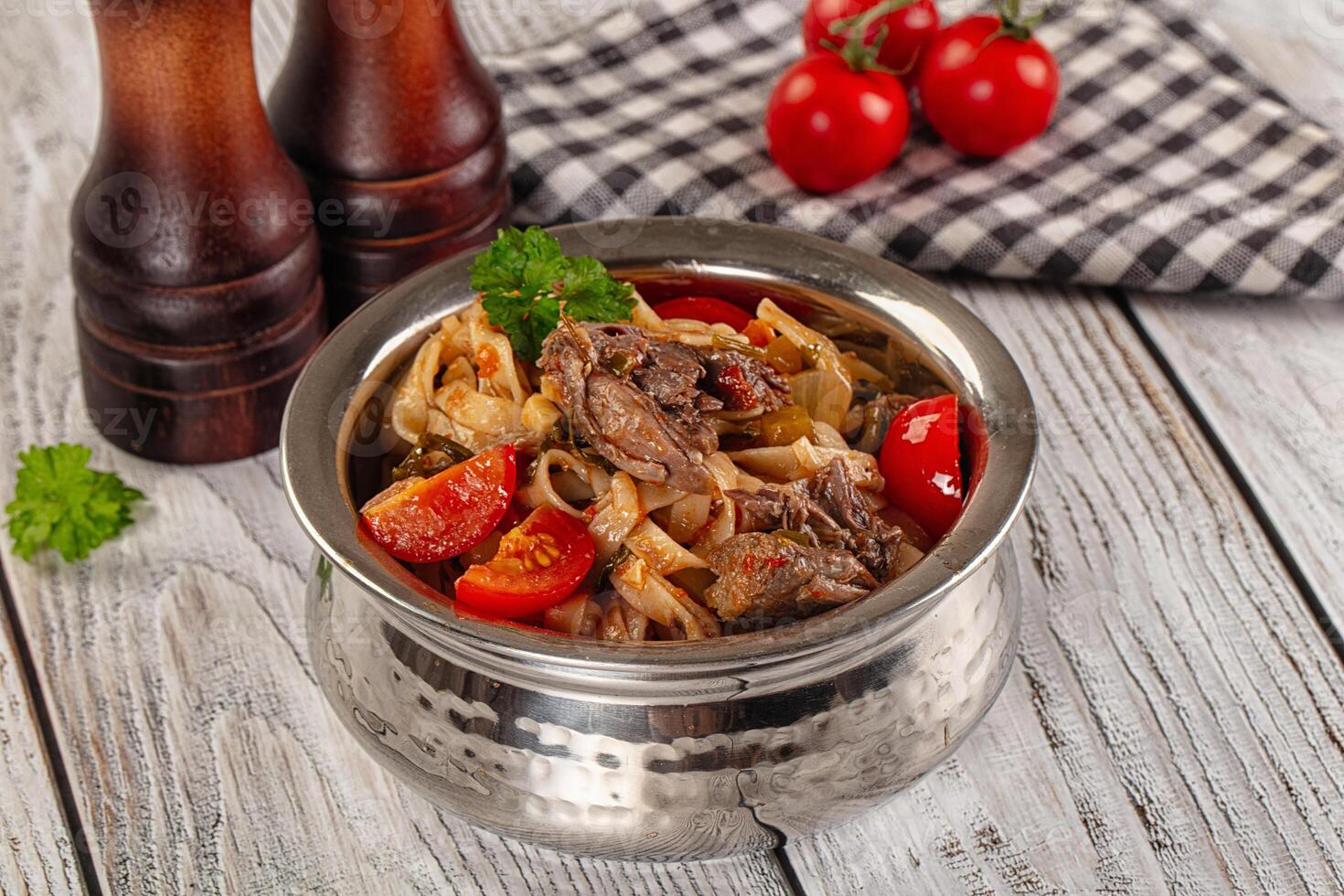 A bowl of food with tomatoes and meat in it photo