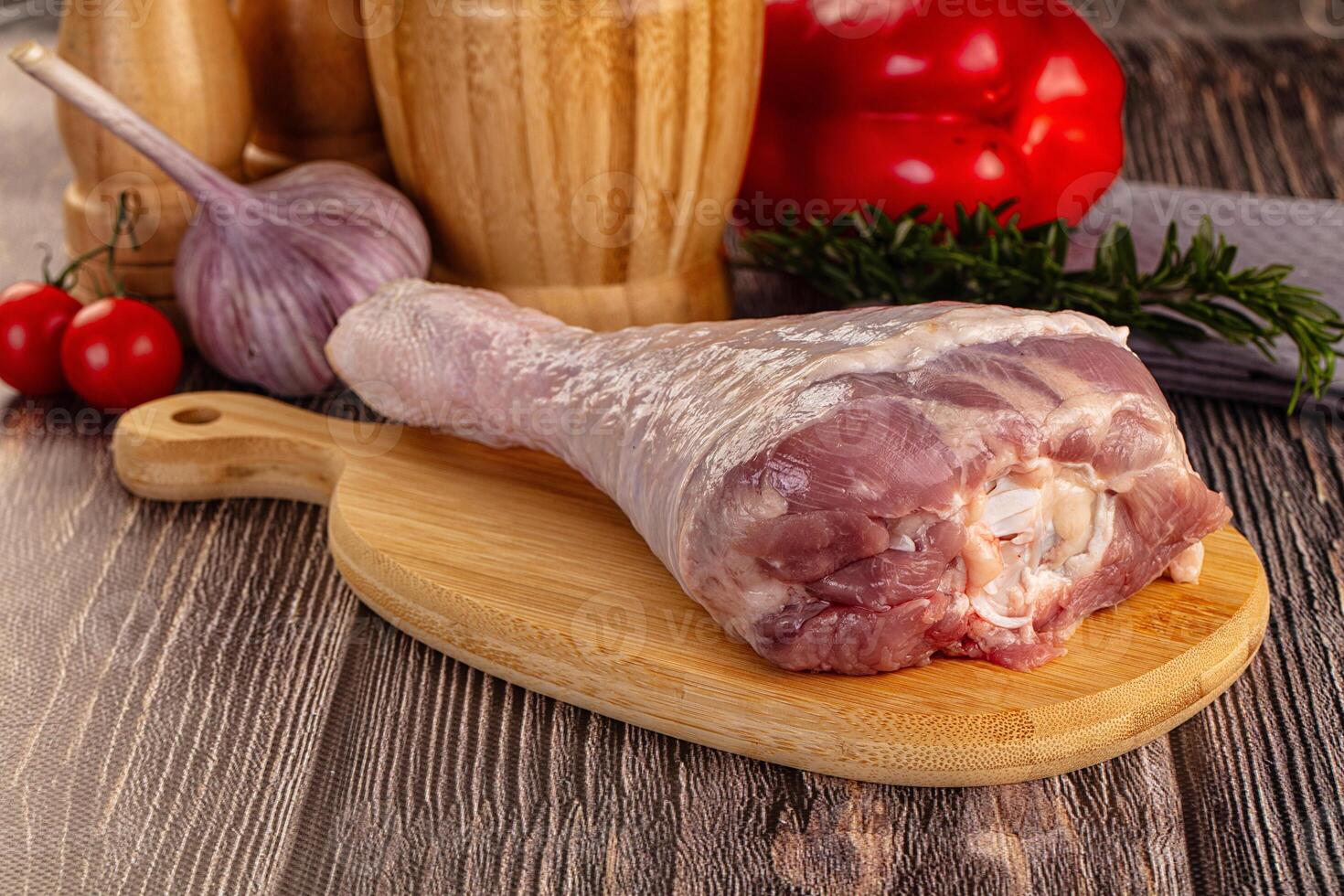 A raw meat on a wooden cutting board with a knife and other ingredients photo
