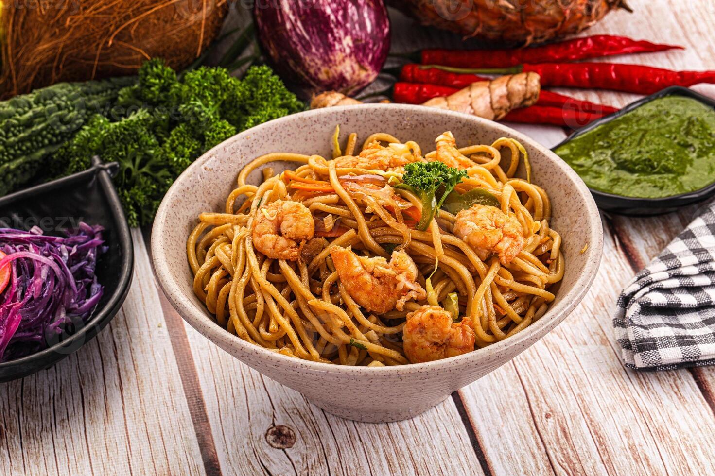 A bowl of noodles and vegetables on a table photo