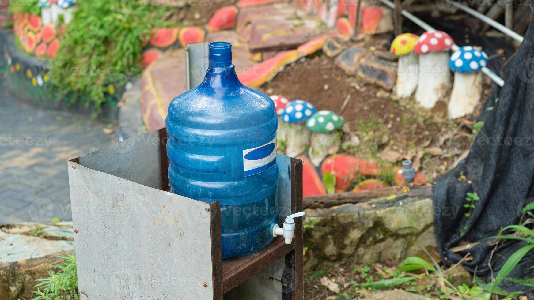 A blue bottle sitting on a table next to a water fountain photo