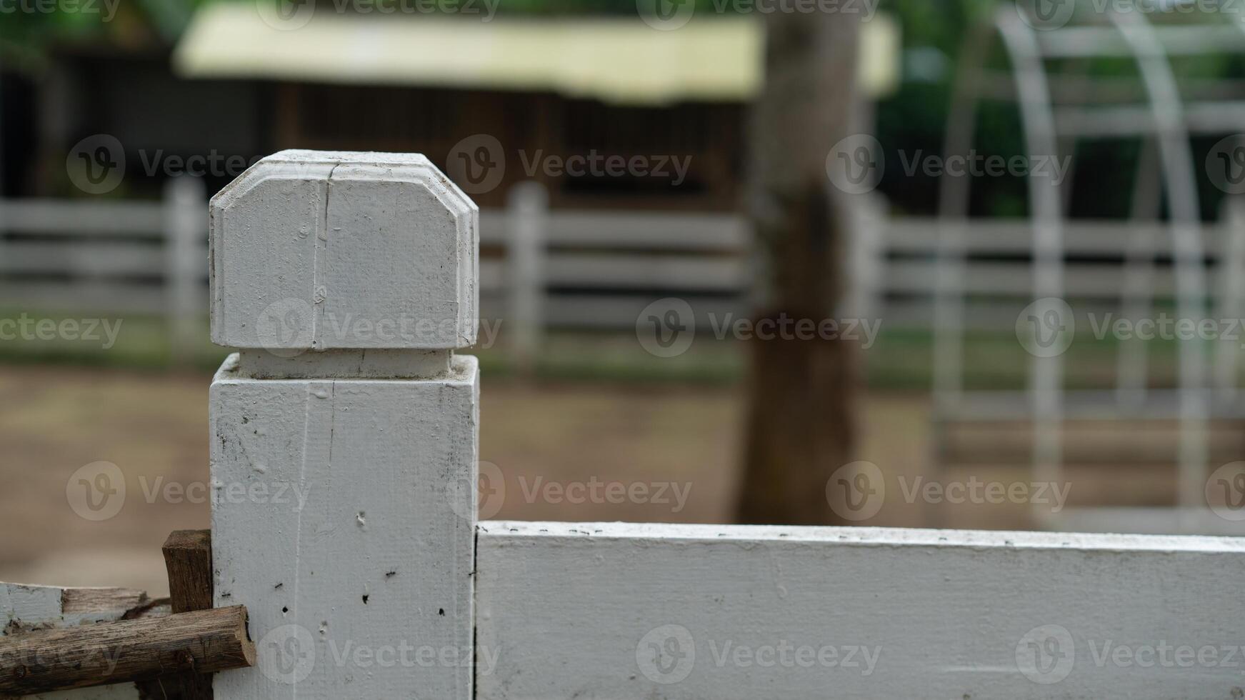 A white fence with a wooden post photo