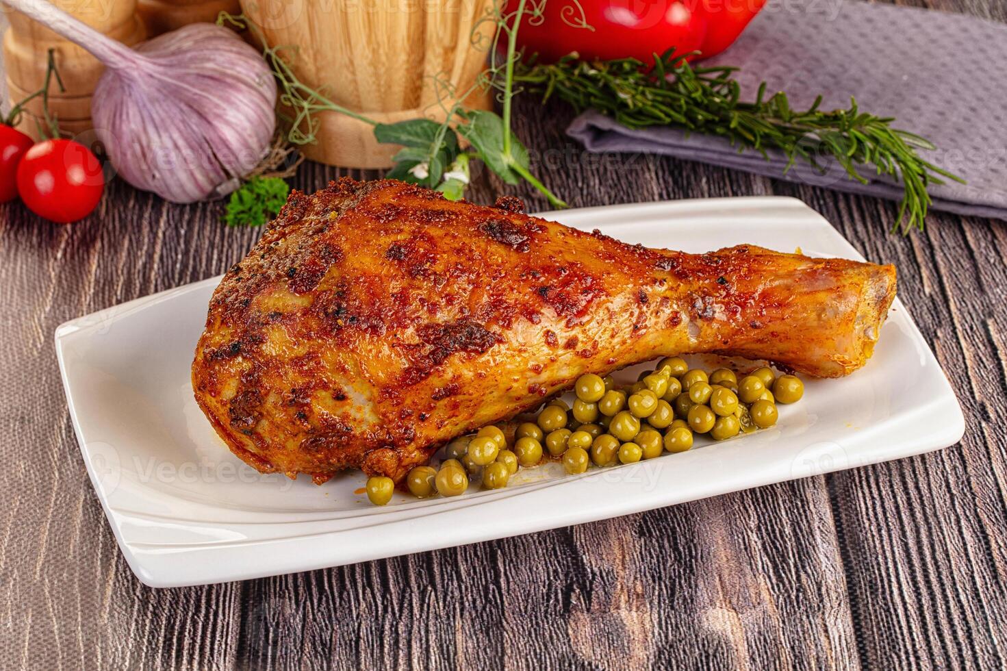 A large piece of chicken with peas and tomatoes photo