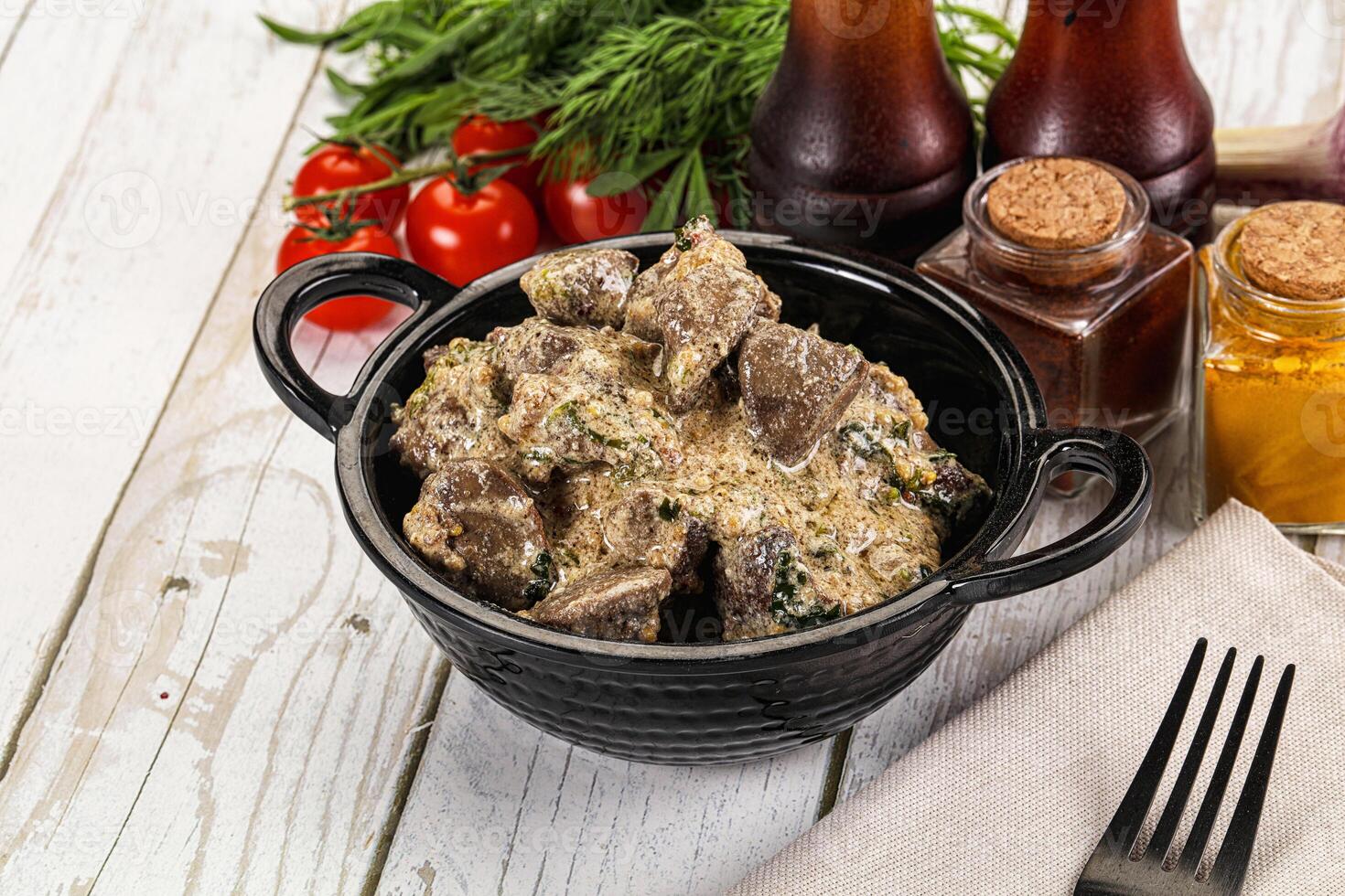 A bowl of food with meat and vegetables on a table photo