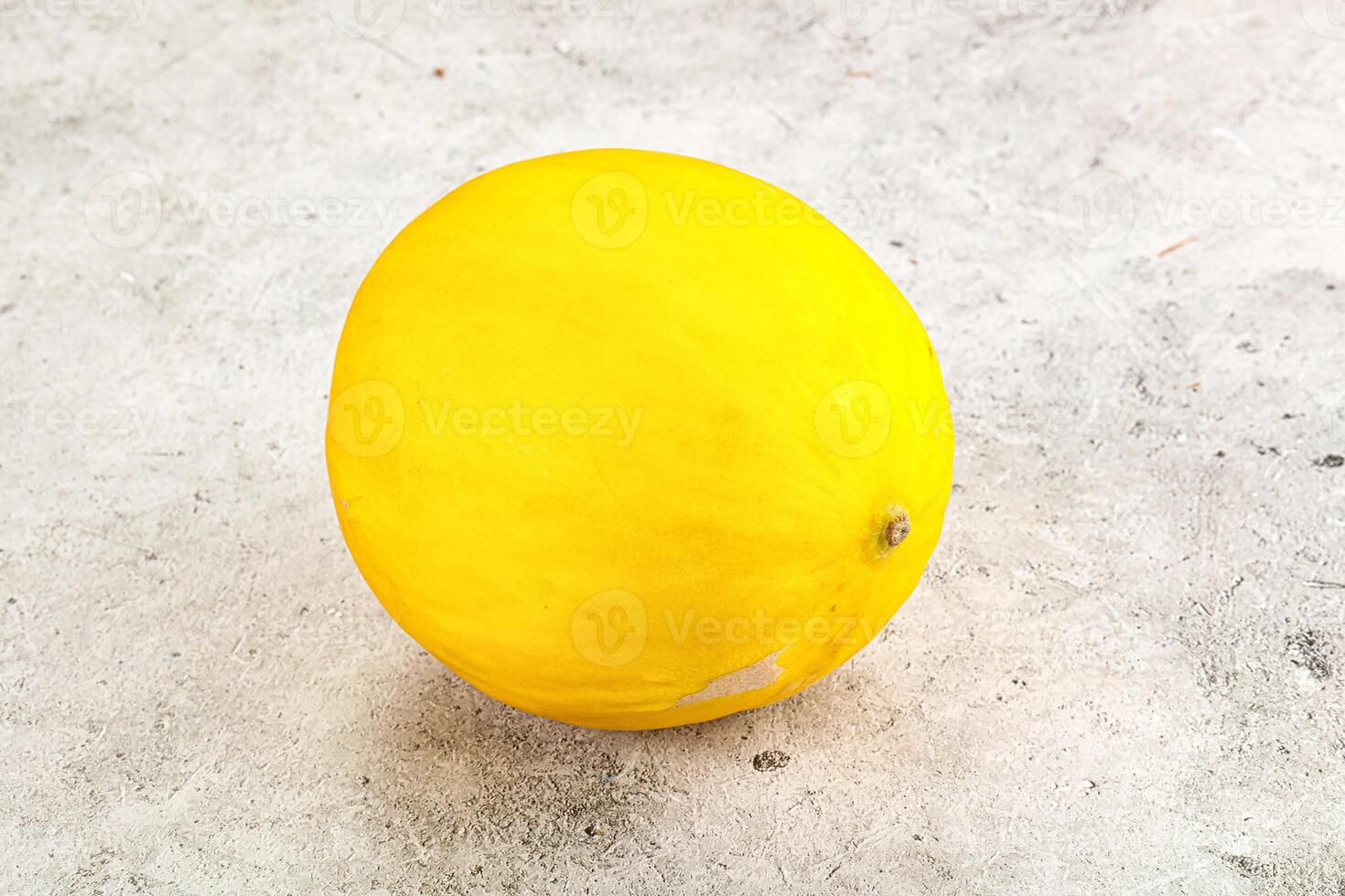 A yellow melon on a table photo