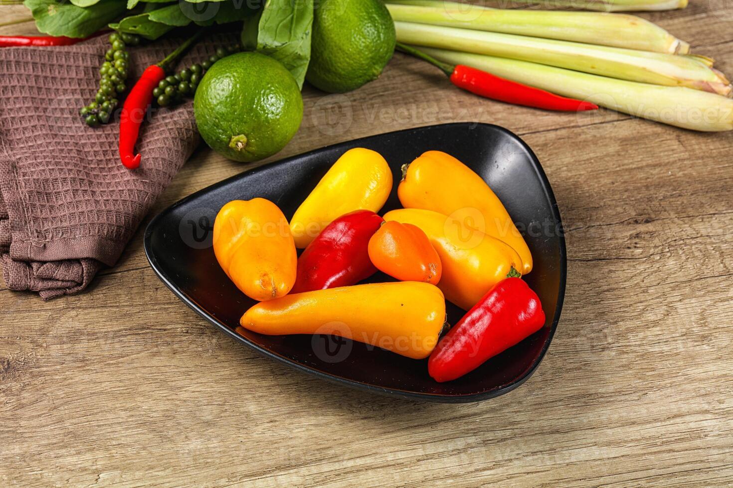 A bowl of peppers and other vegetables on a table photo