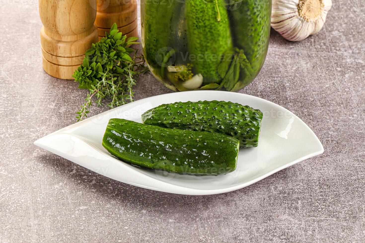 A jar of pickles and a plate with cucumbers photo