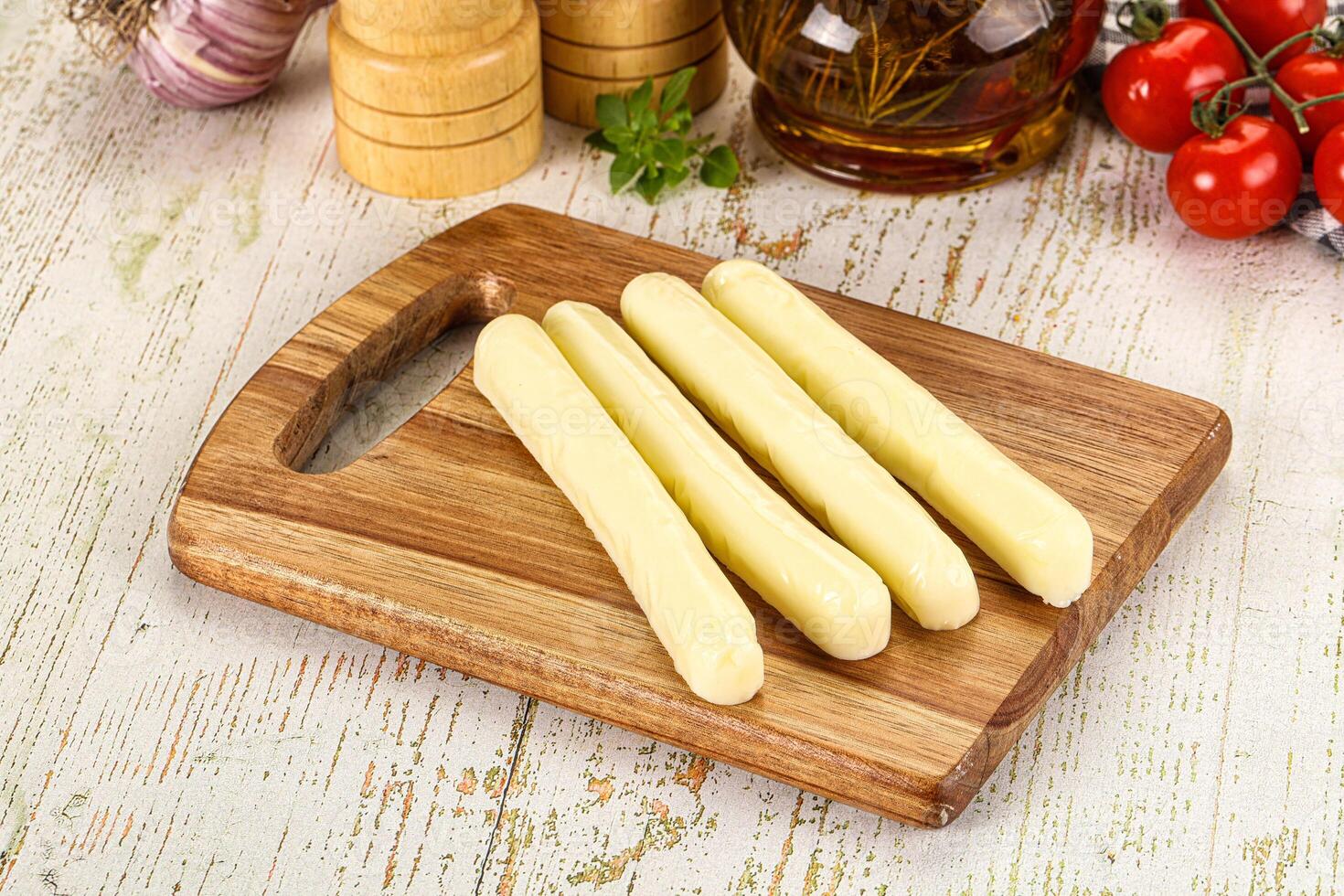 A wooden cutting board with four pieces of cheese photo