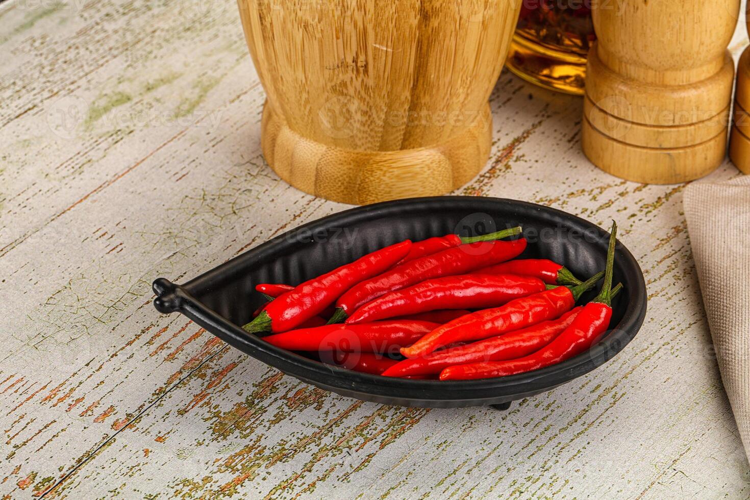 A bowl filled with red peppers on a table photo