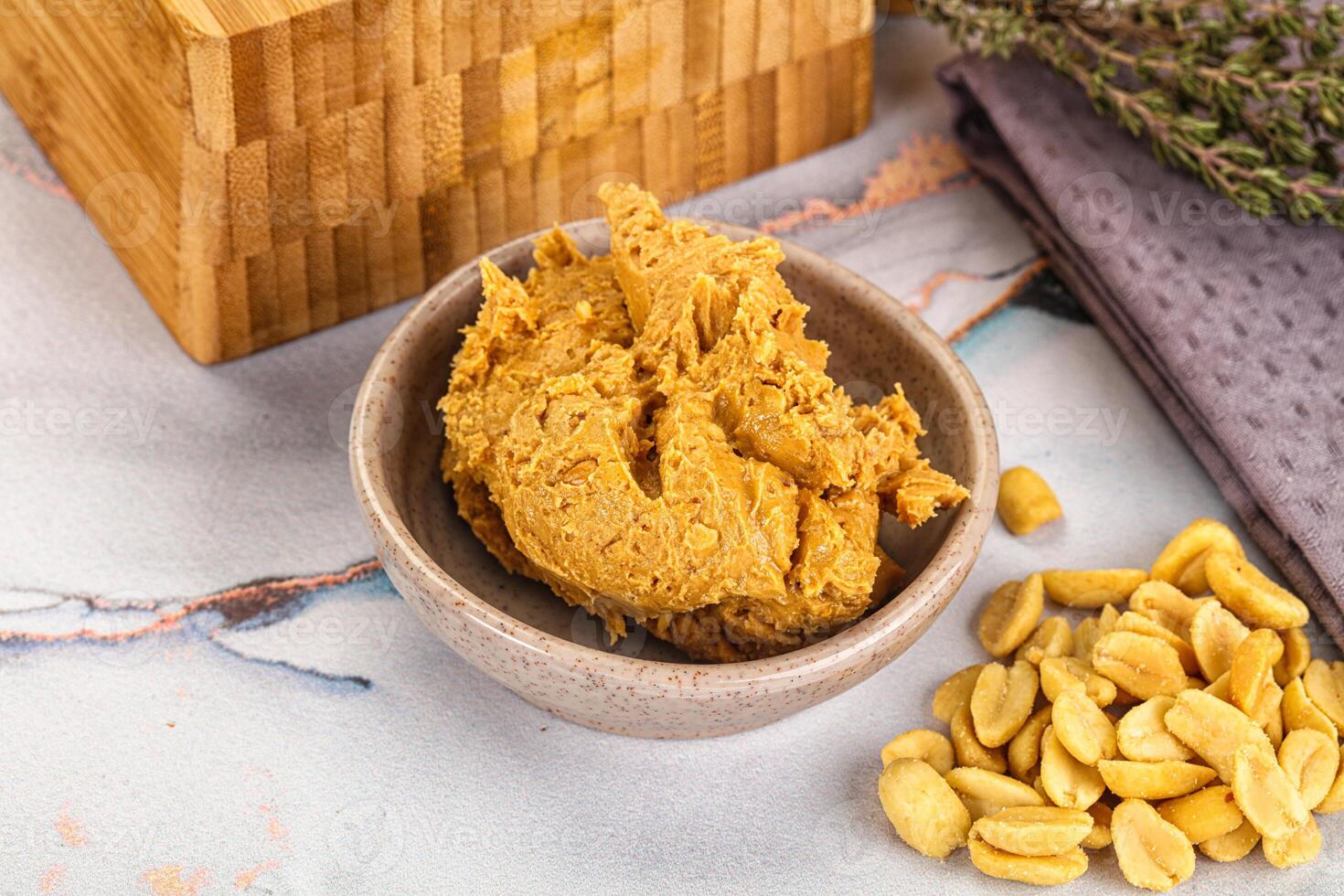 A bowl of peanut butter next to a wooden box photo