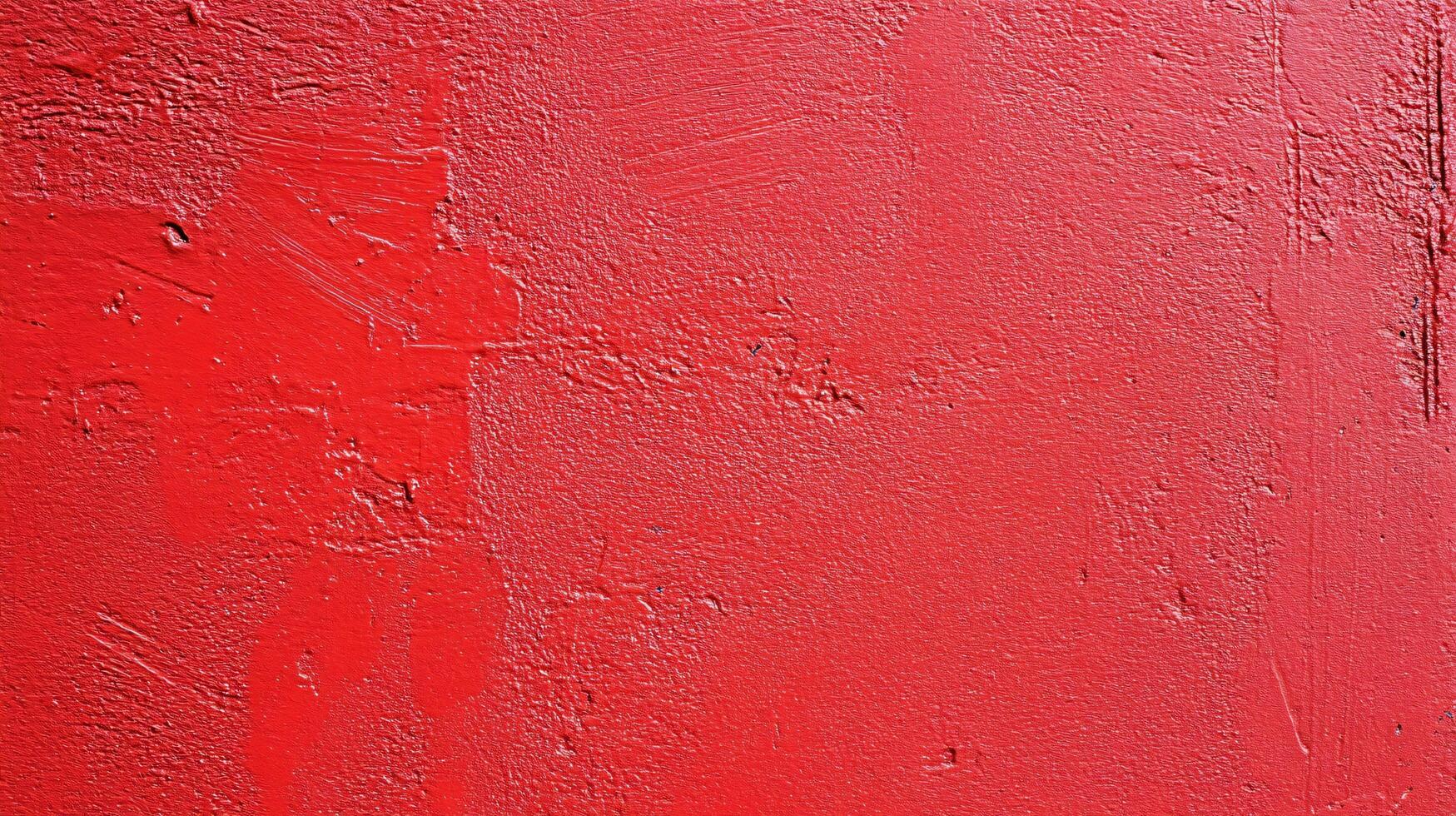 Red wall with a red paint splatter on it. The wall is textured and has a rough surface photo