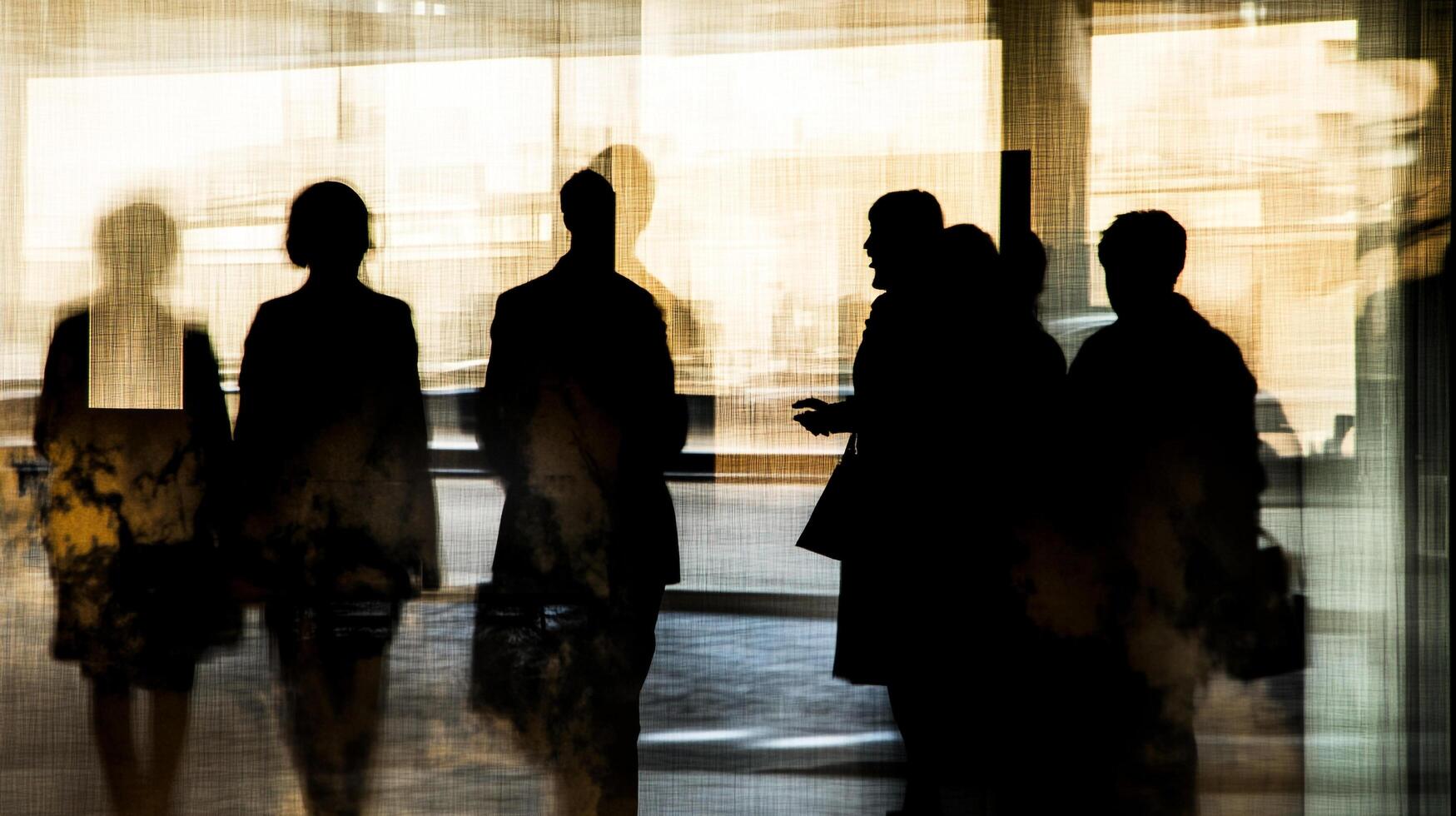 Silhouetted figures create a mysterious office scene. An abstract study in light, shadow, and the human form within an urban environment. photo