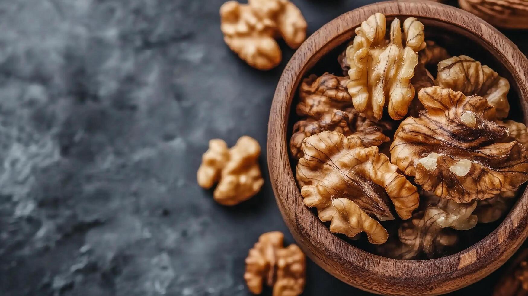 Wooden bowl filled with nutritious walnut halves on a textured surface. Close-up shot, highlighting the kernels' texture. photo