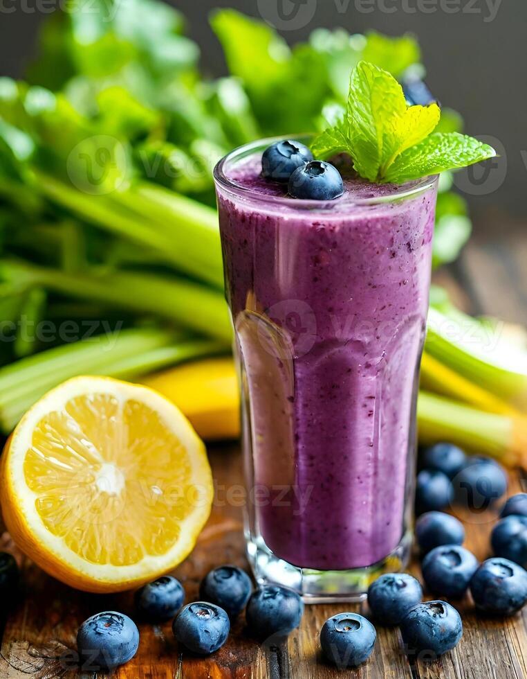 Refreshing berry cocktail with blueberries, celery, lemon and mint on wooden table photo