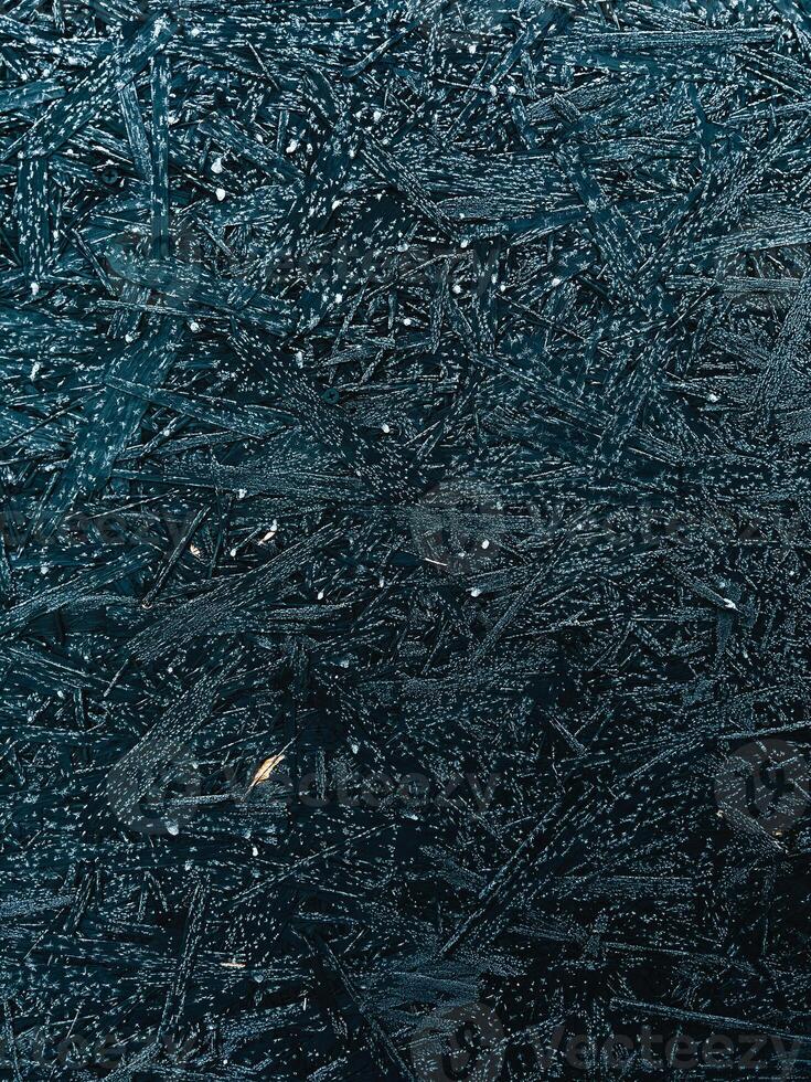 Close up view of a frozen wooden surface covered with hoarfrost crystals, creating intricate and beautiful patterns, showcasing the delicate beauty of nature in winter. frozen wooden background photo