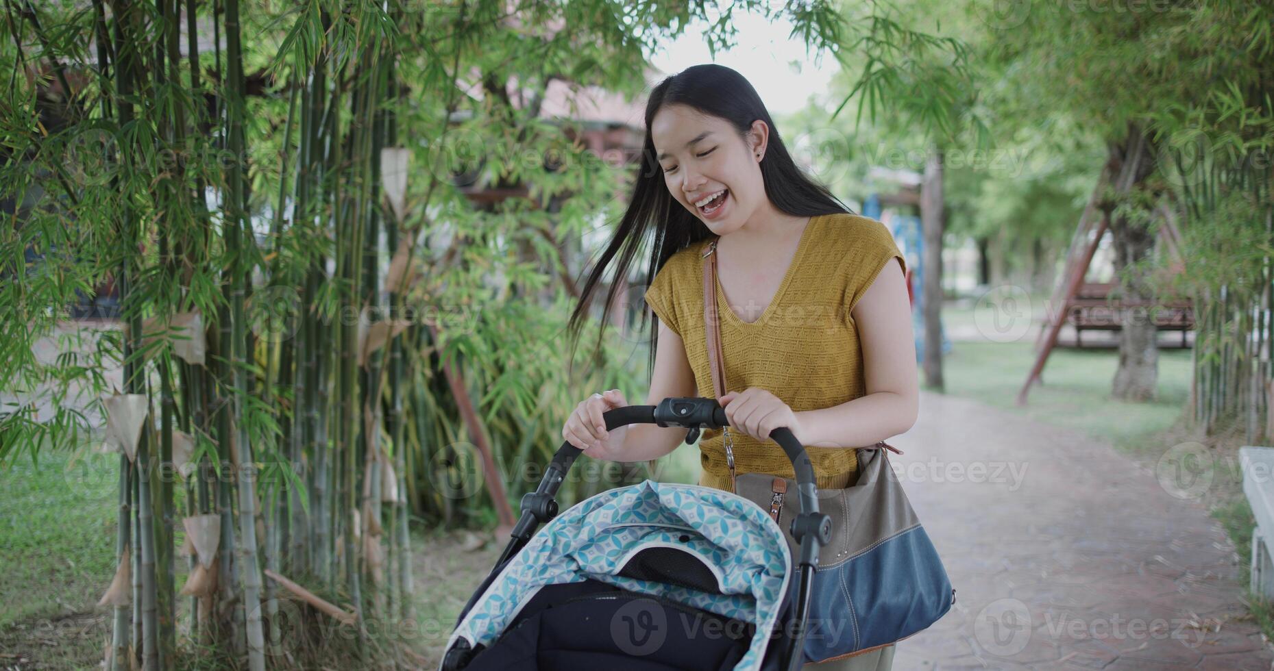 Portrait of Beautiful Asian woman walk with little boy in stroller in front of coffee shop with relaxing holiday atmosphere. photo