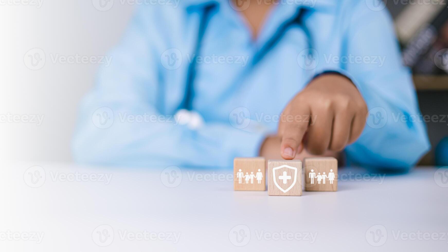 Human hands point to protection life insurance and investing to reduce risk, Doctor selects a wooden block with a symbol of protection and protection, Health care planning and insurance concept. photo