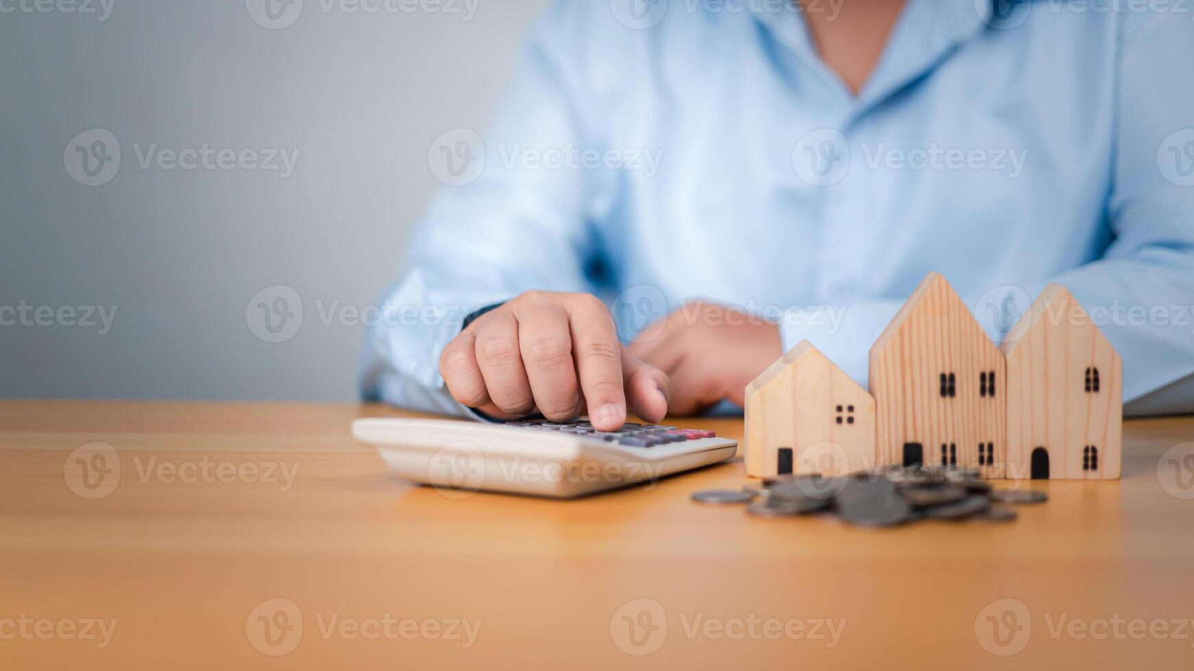 House with money, Pressing a calculator beside a house model and coins, Concept of finance or refinance real estate, Property cash flow, Saving money for retirement, investment, loan, real, mortgage. photo