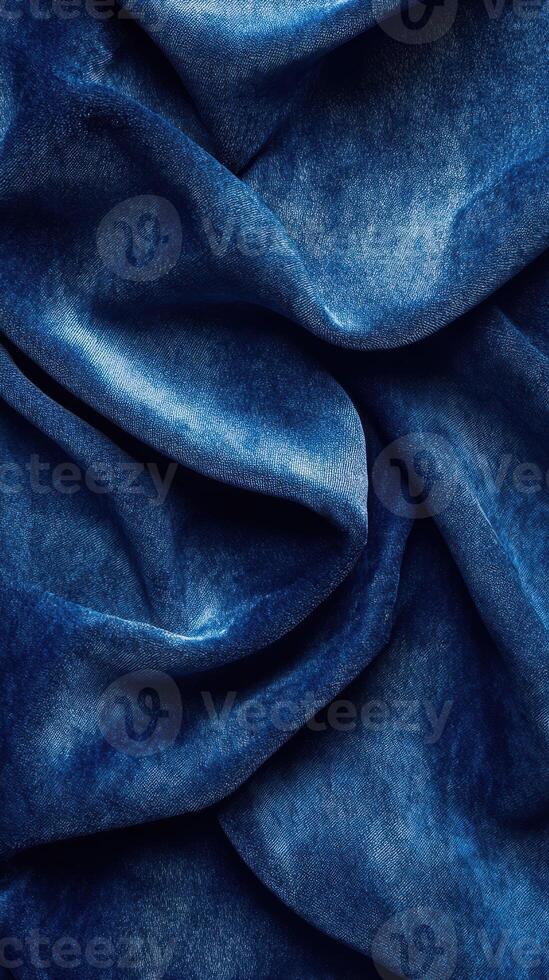 Detailed texture of crumpled blue fabric captured in natural light showcasing intricate folds and shades photo