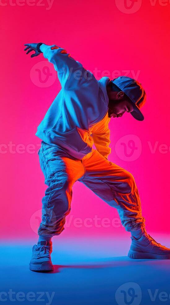 Stylish dancer performing dynamic moves against a vibrant pink and blue backdrop in urban attire photo
