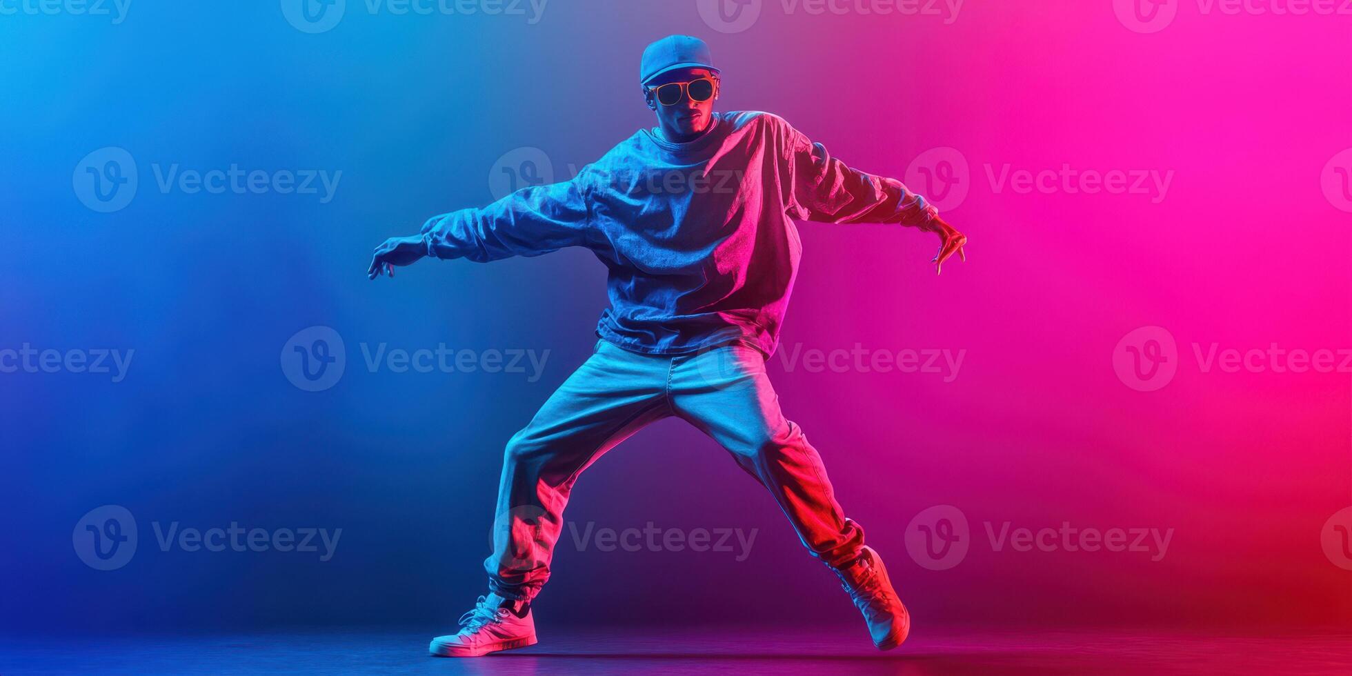 Dynamic hip hop dancer performs under bright blue and pink lights in an urban setting during a late-night event photo