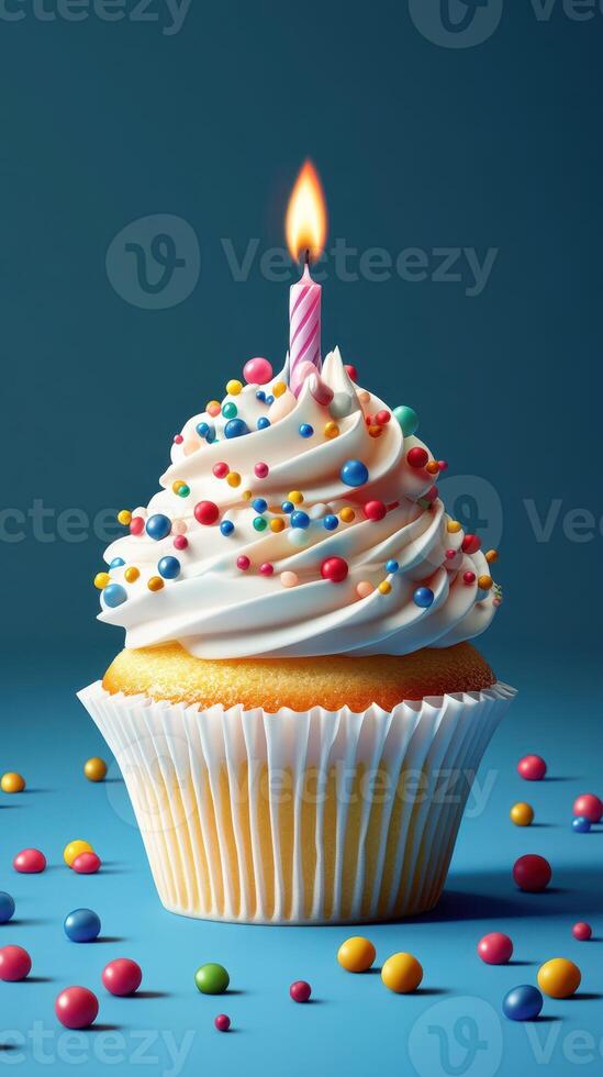 Colorful cupcake with a lit candle against a vibrant blue background and scattered candy on the surface photo
