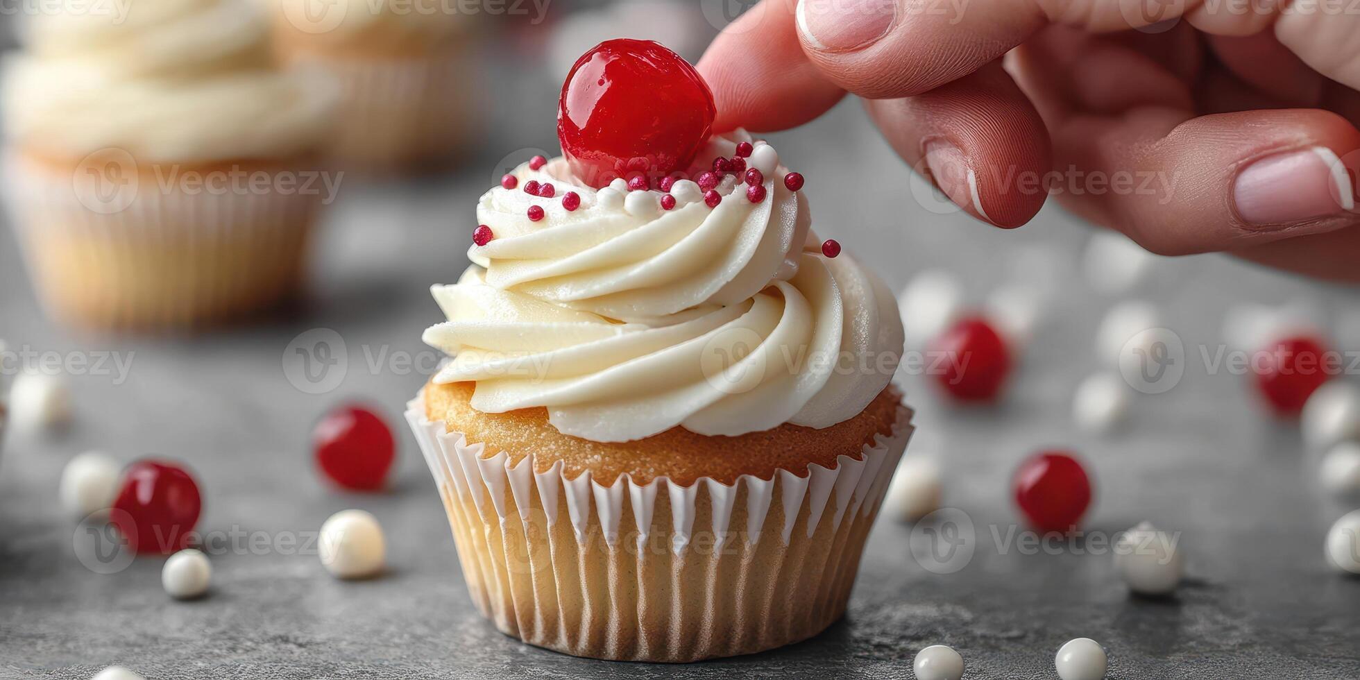 Decorating a delightful cupcake with frosting and cherry on a festive table setting photo